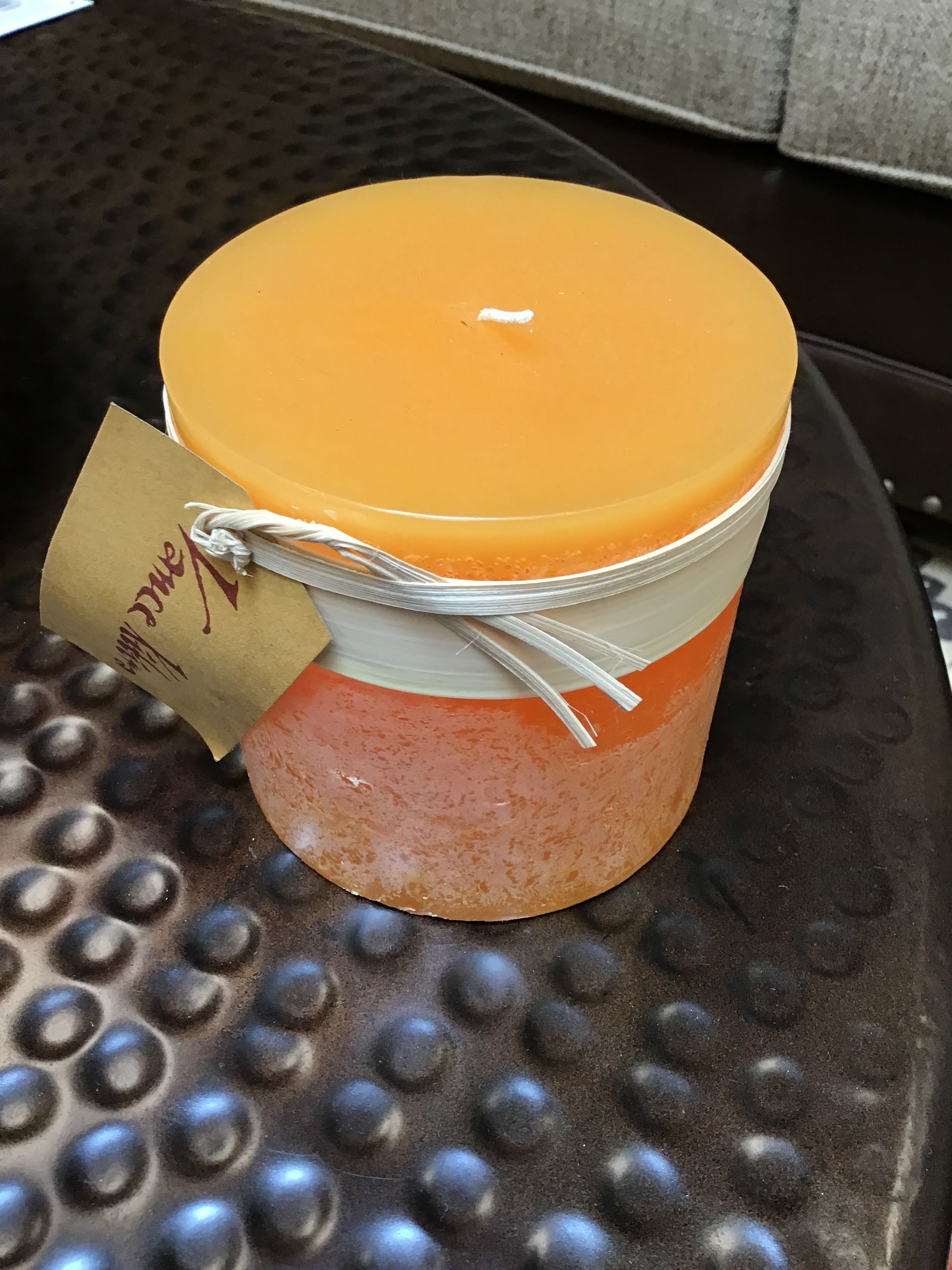 Jar with a yellow lid and pinkish body on a textured surface