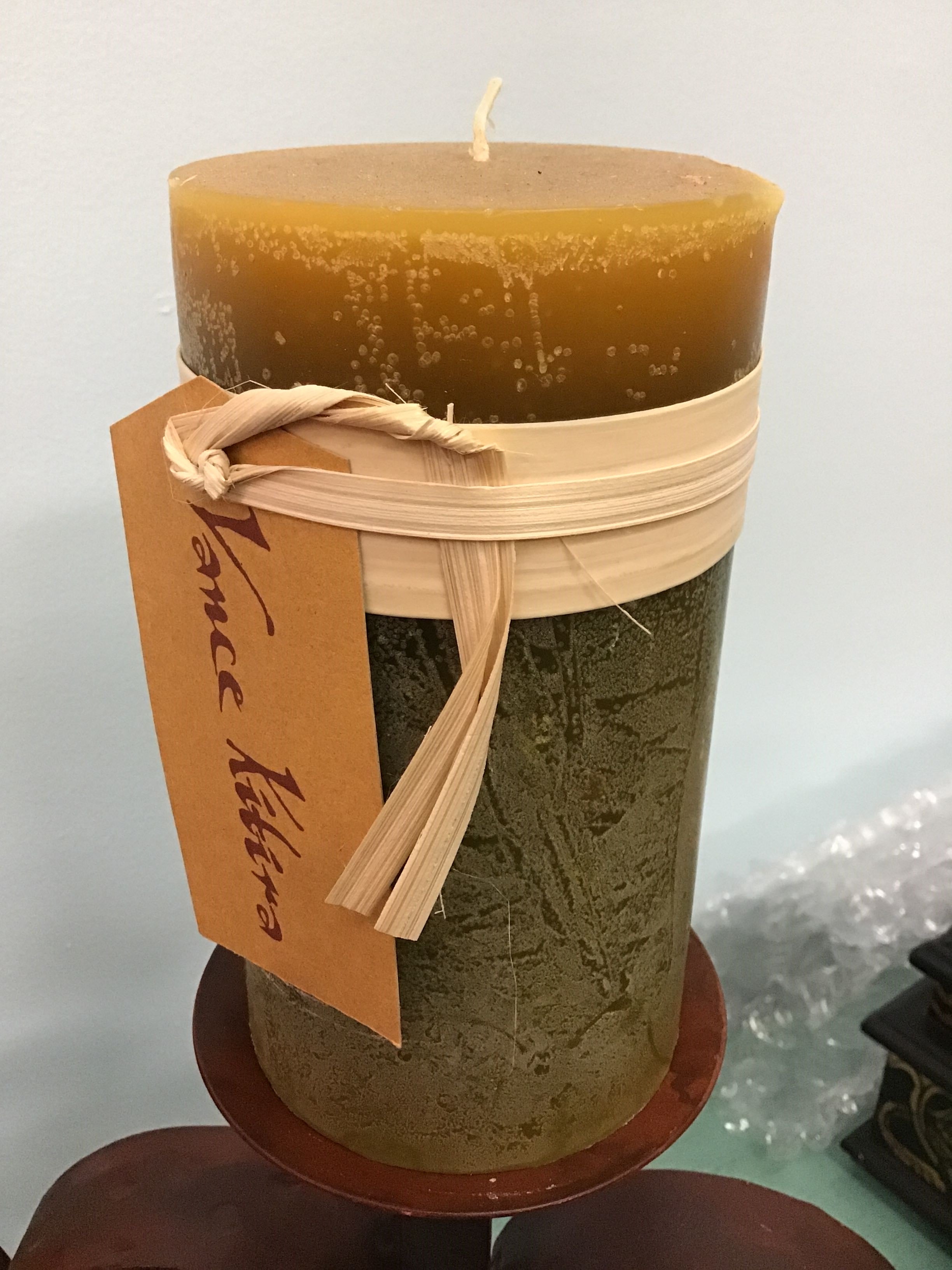 Brown candle with a decorative tag on a white background