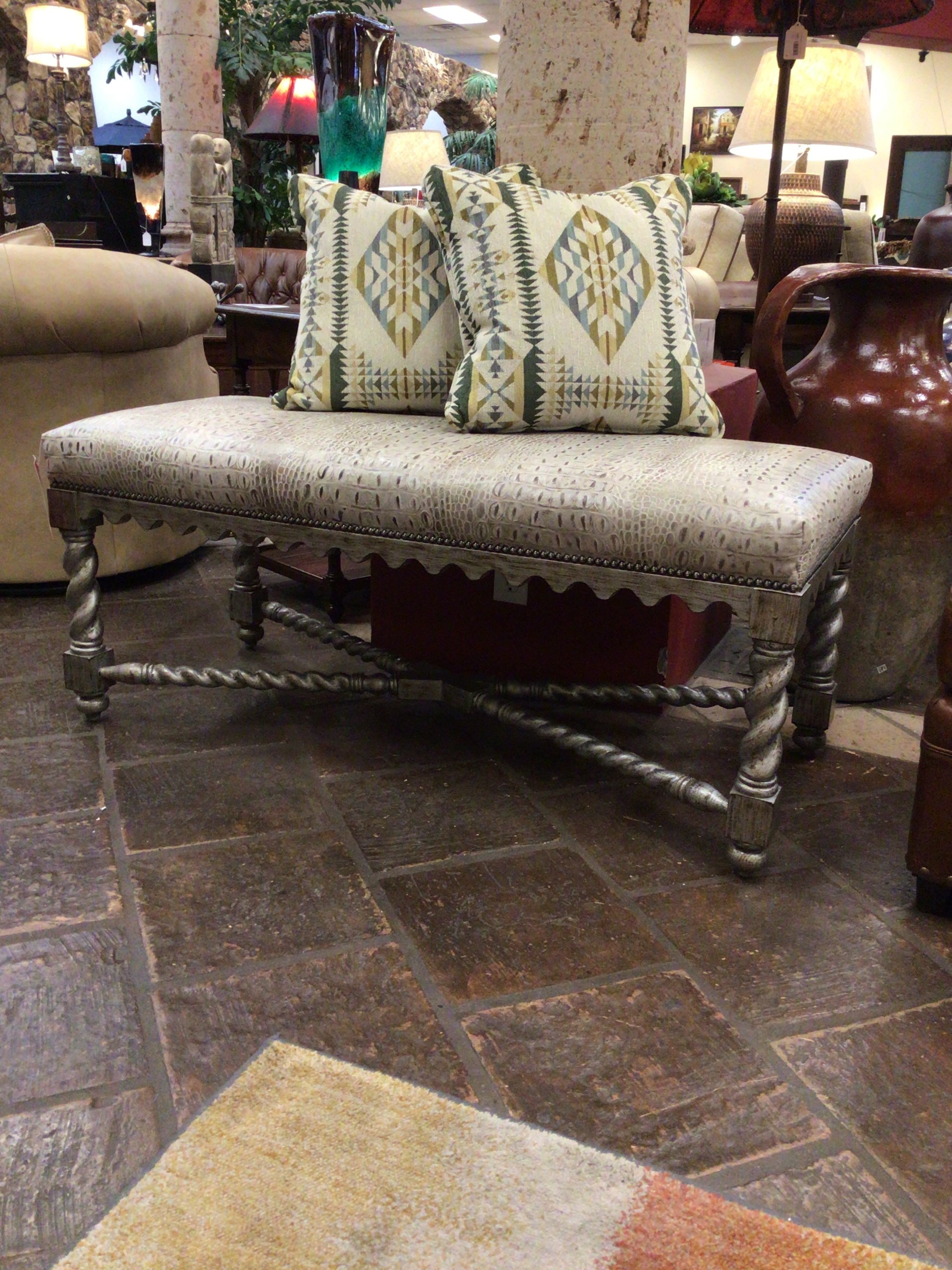Decorative bench with patterned cushions in a showroom setting