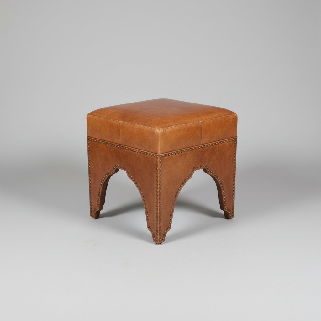 Brown leather ottoman on a stone floor with a red bag in the background