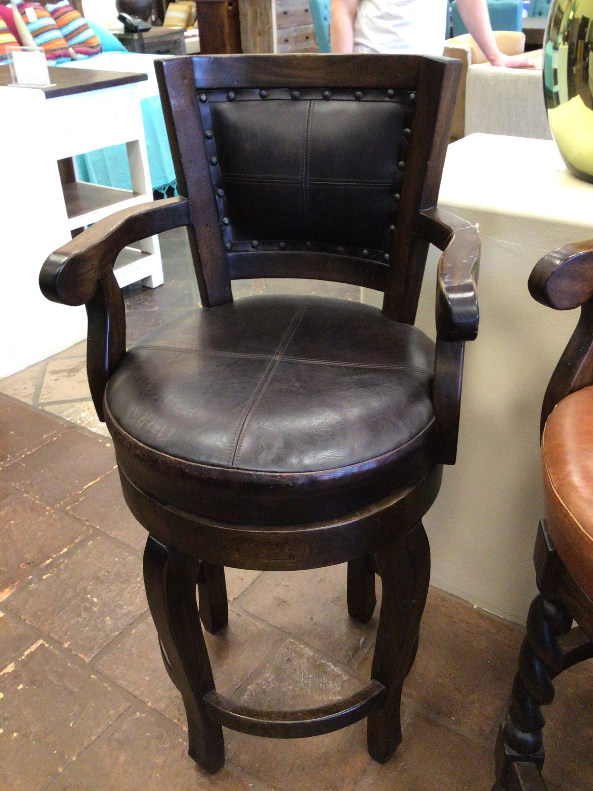 Dark wooden bar stool with leather seat in a casual setting