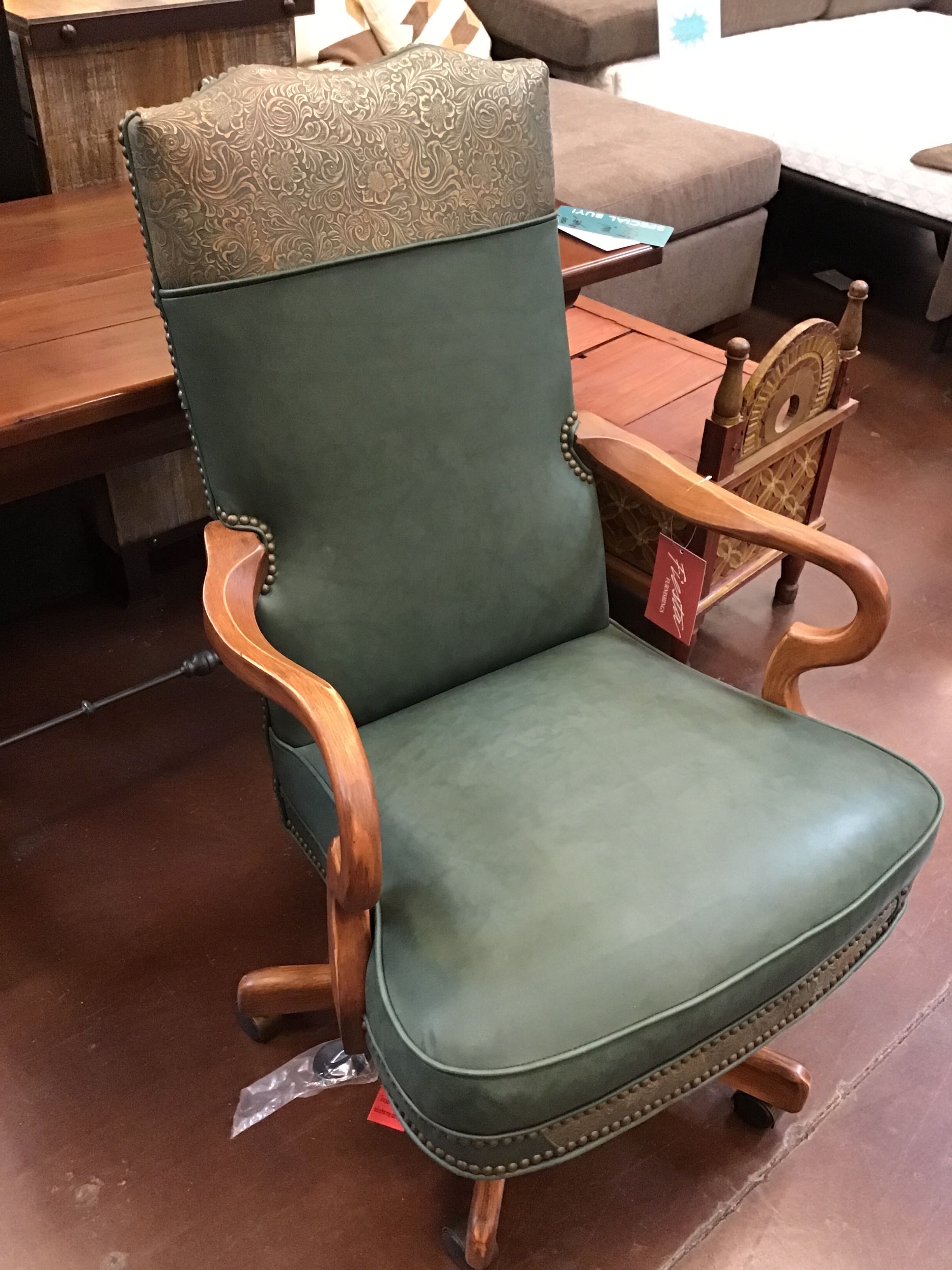 Green armchair with wooden frame on a brown floor