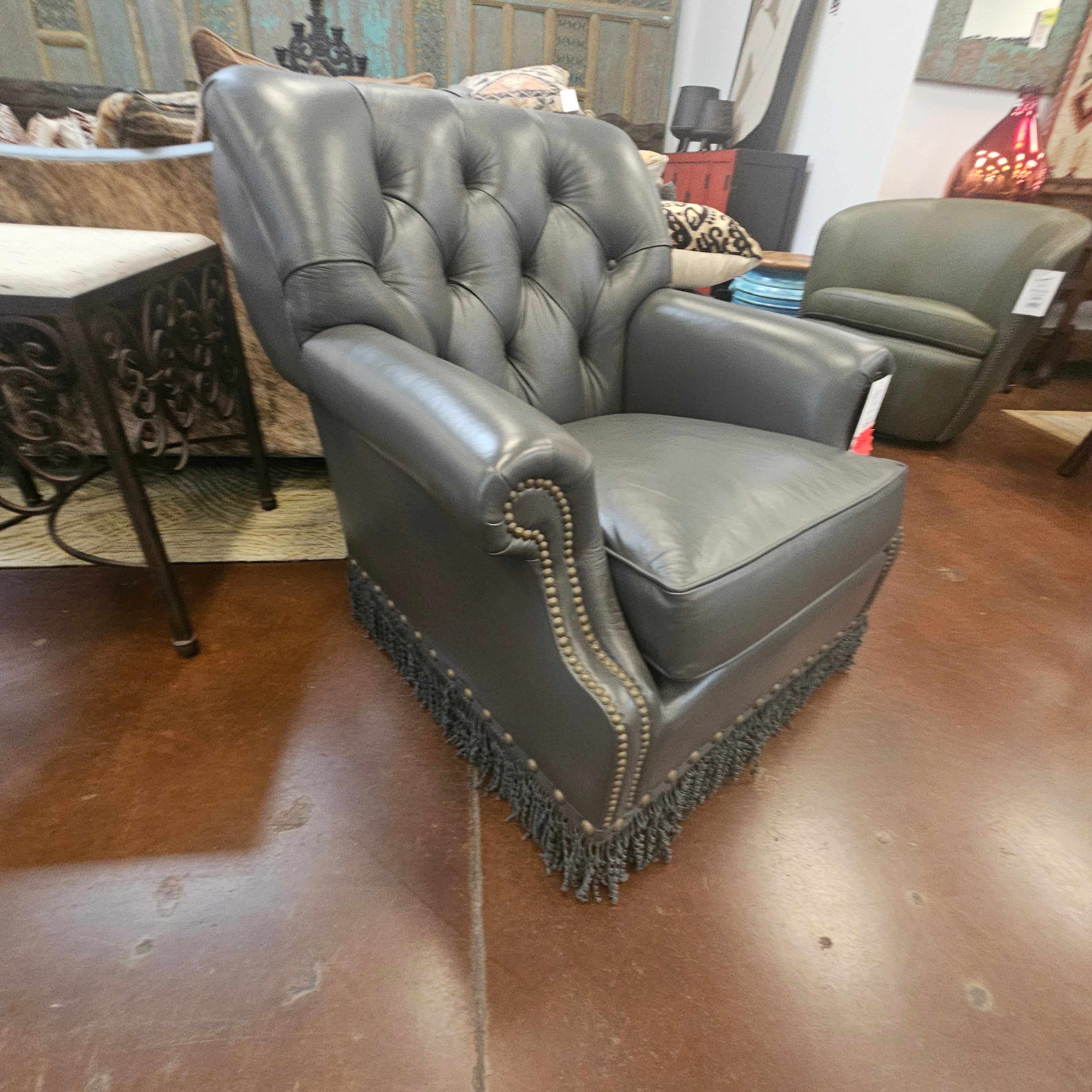 steel blue leather chair with tufted design on a wooden floor