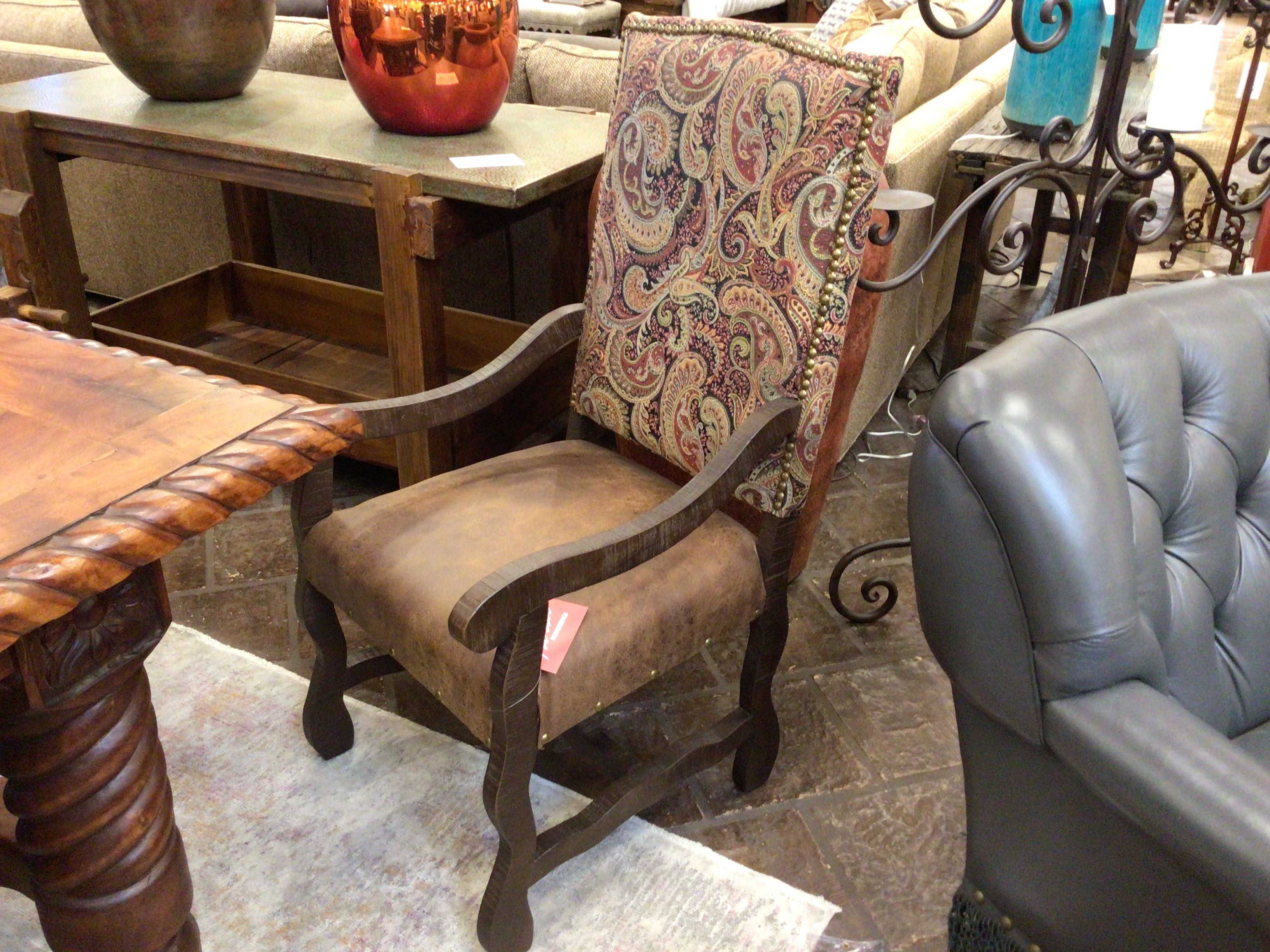 Decorative armchair with patterned backrest in a furniture store setting
