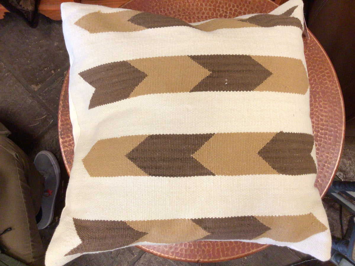 Decorative pillow with geometric pattern on a round wooden table