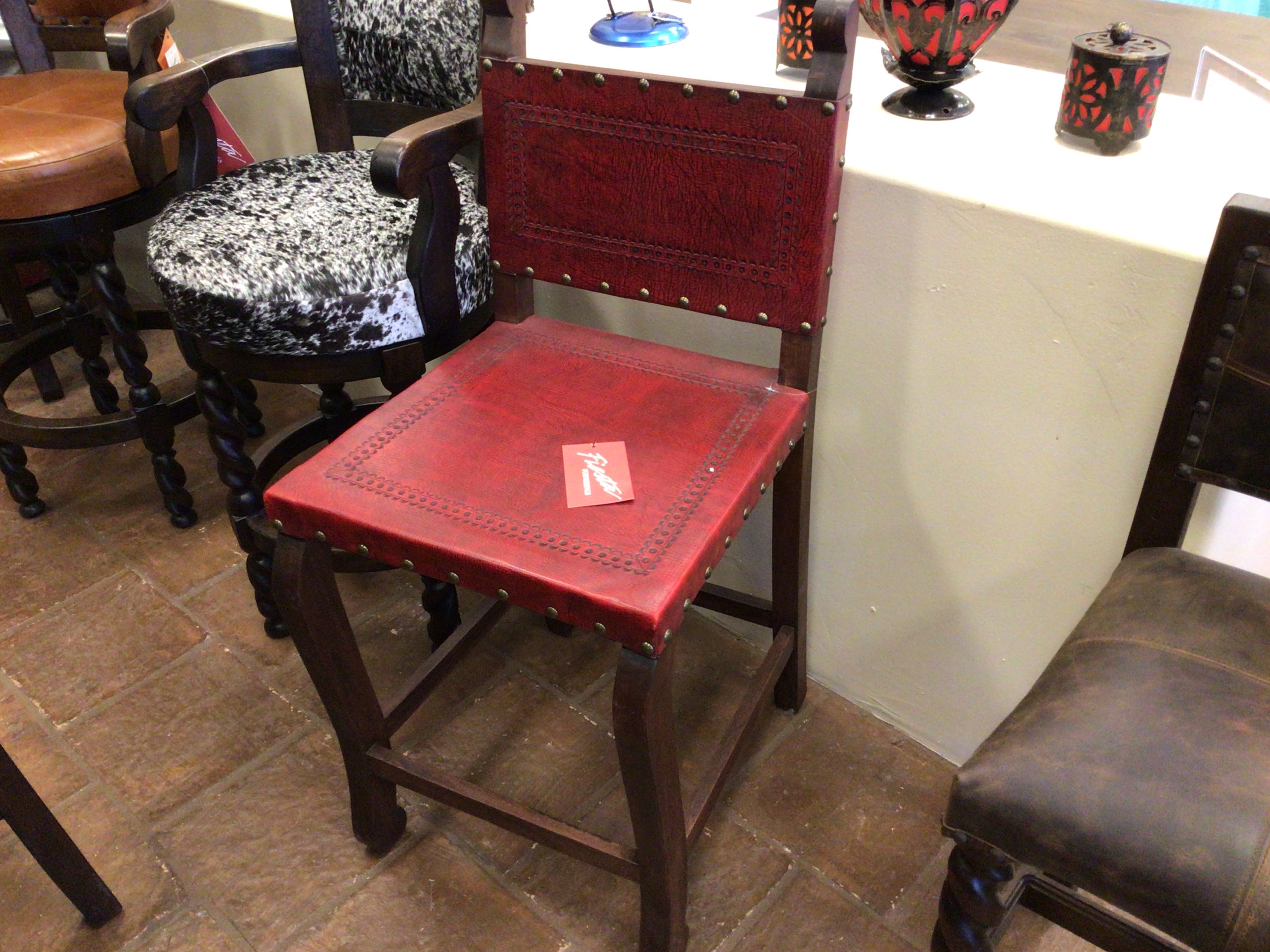 Red leather bar stool with patterned cushion in a bar setting