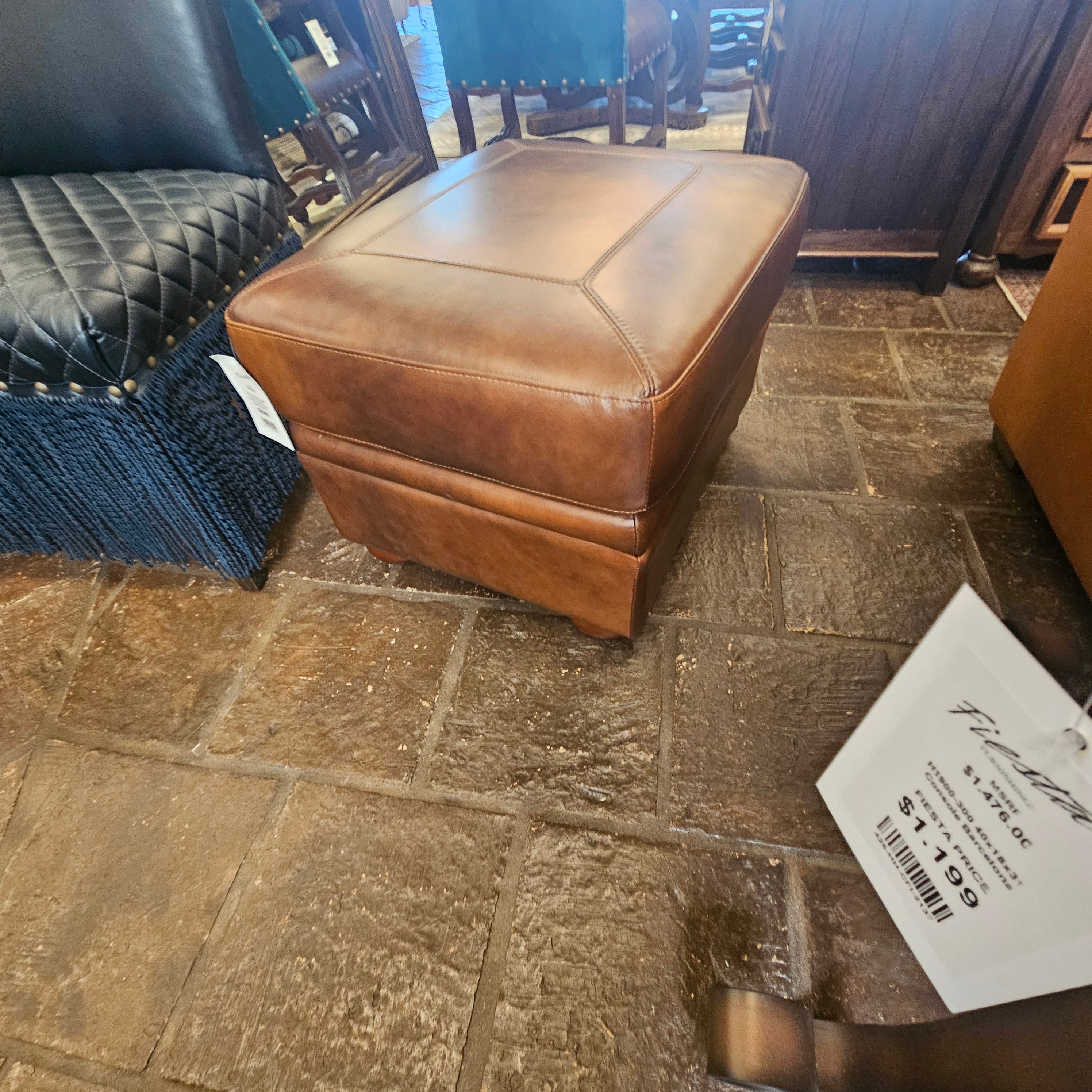 Brown leather seat cover on a chair with a price tag in a store setting.