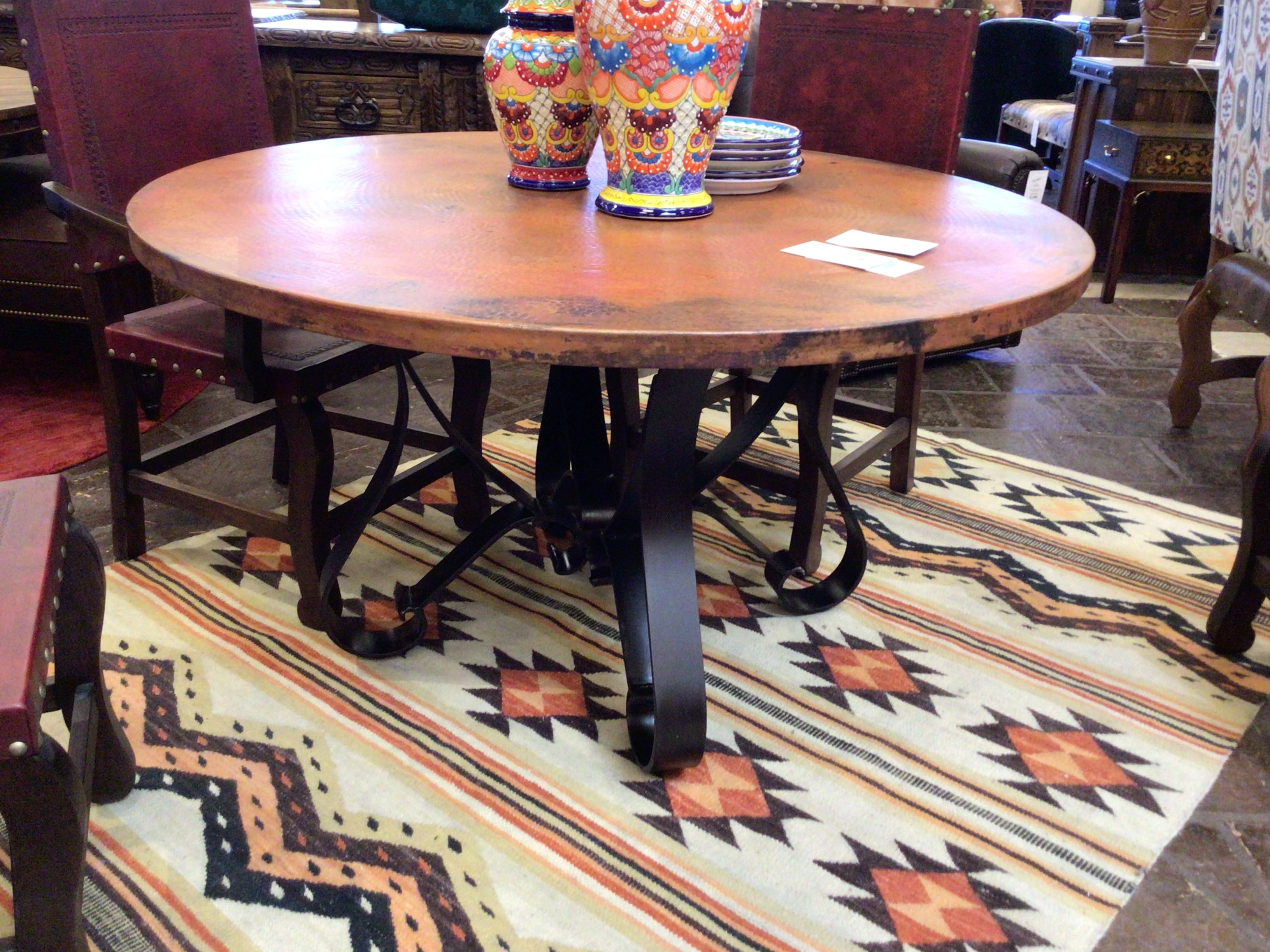 Wooden dining table with decorative vases on a patterned rug