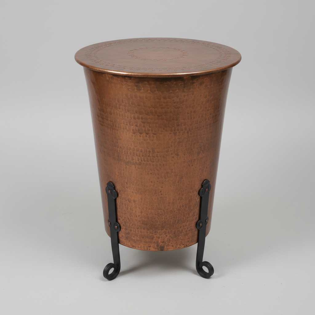 Bronze cylindrical table with engraved patterns on a wooden floor.