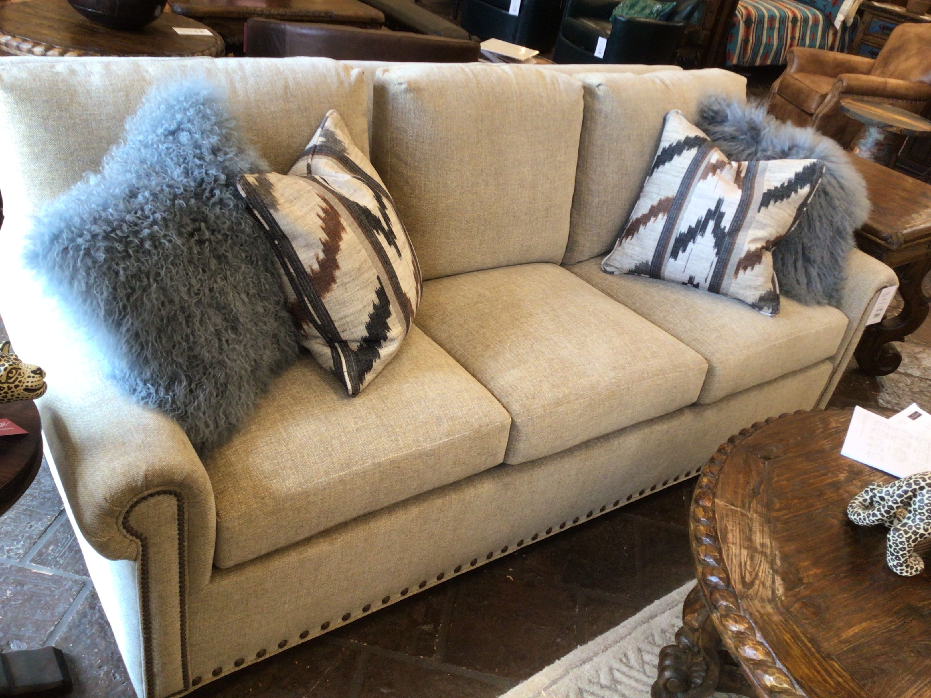 Beige sofa with patterned pillows in a room setting