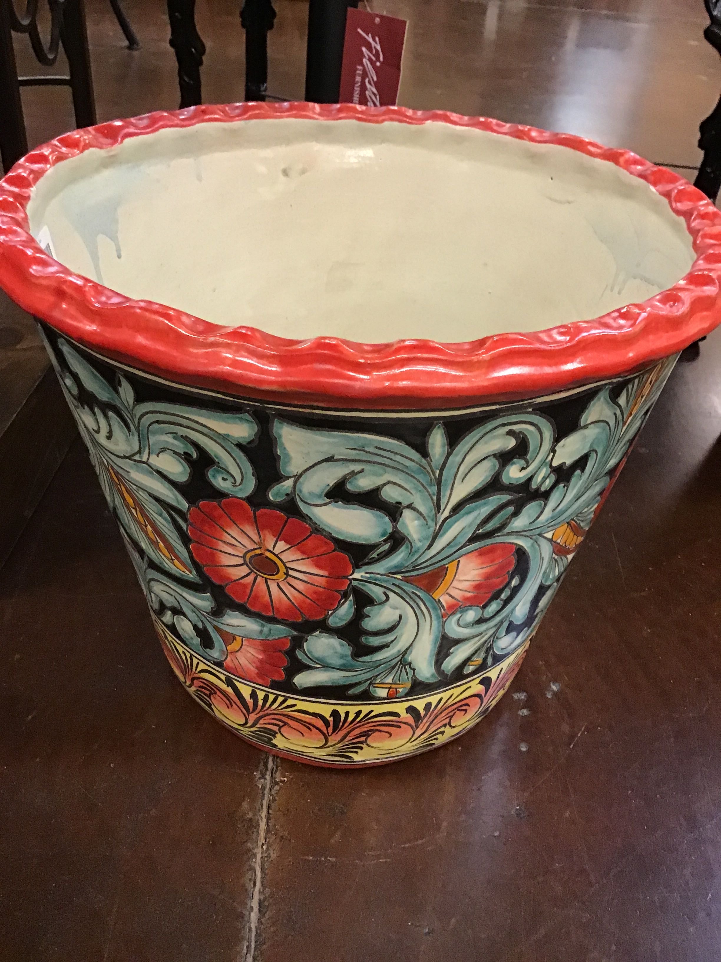 Decorative ceramic pot with floral patterns on a wooden floor