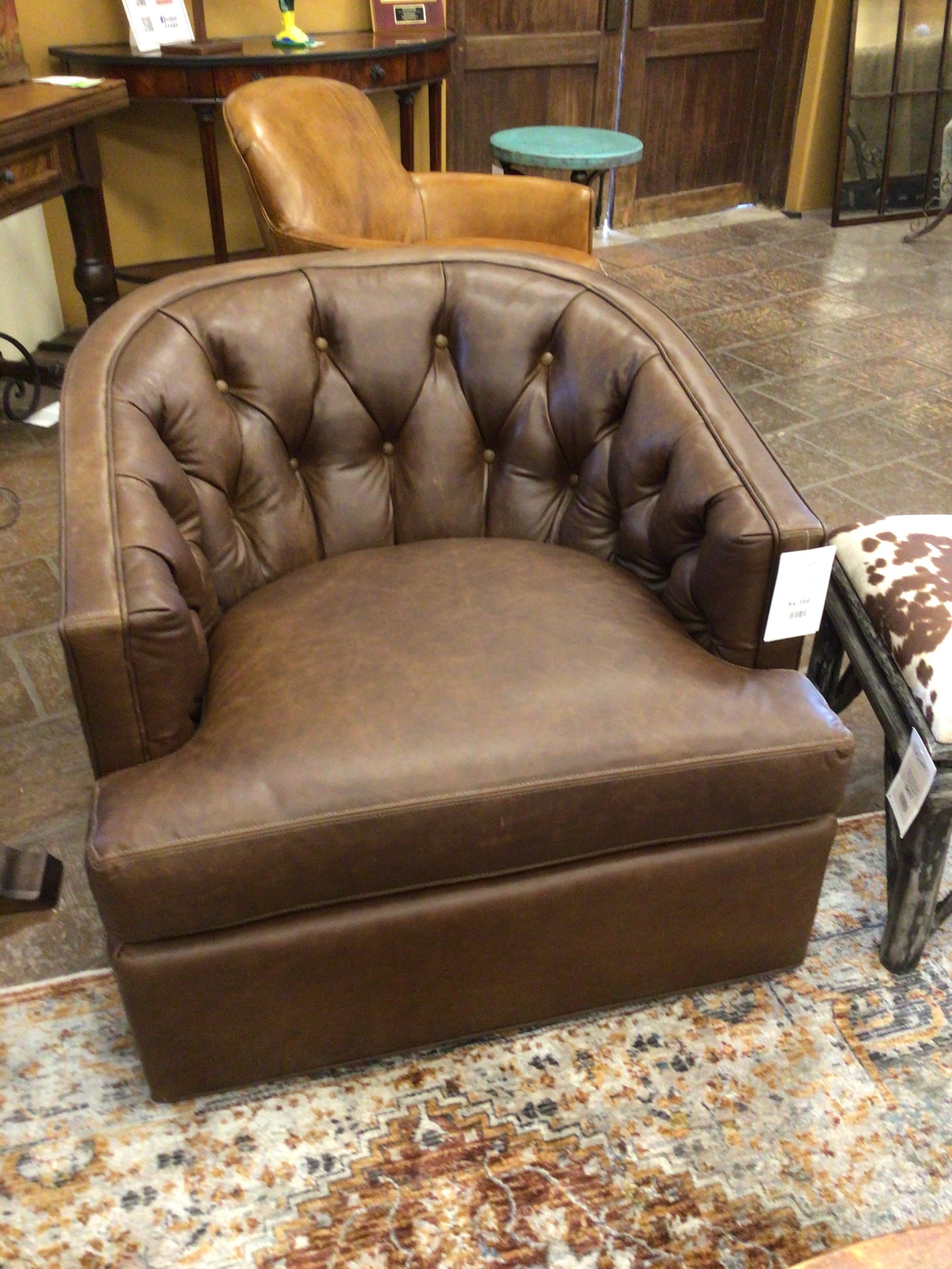 Brown leather armchair in a room with wooden furniture and a patterned rug.