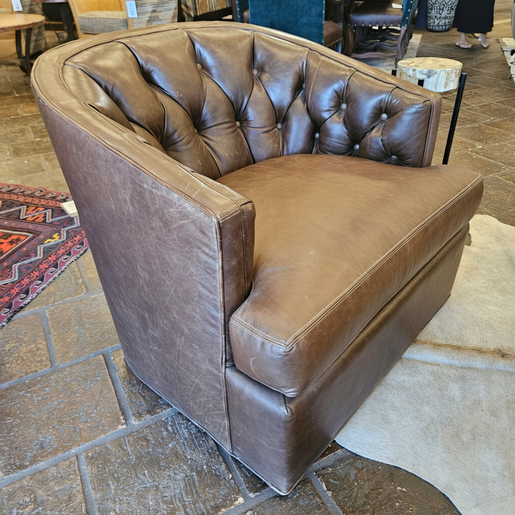 Brown leather sofa in a store setting with a stone floor.