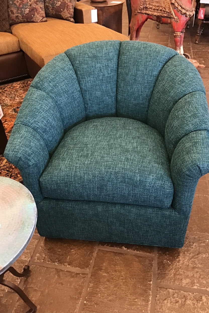 Blue textured armchair in a room with a patterned rug and furniture.