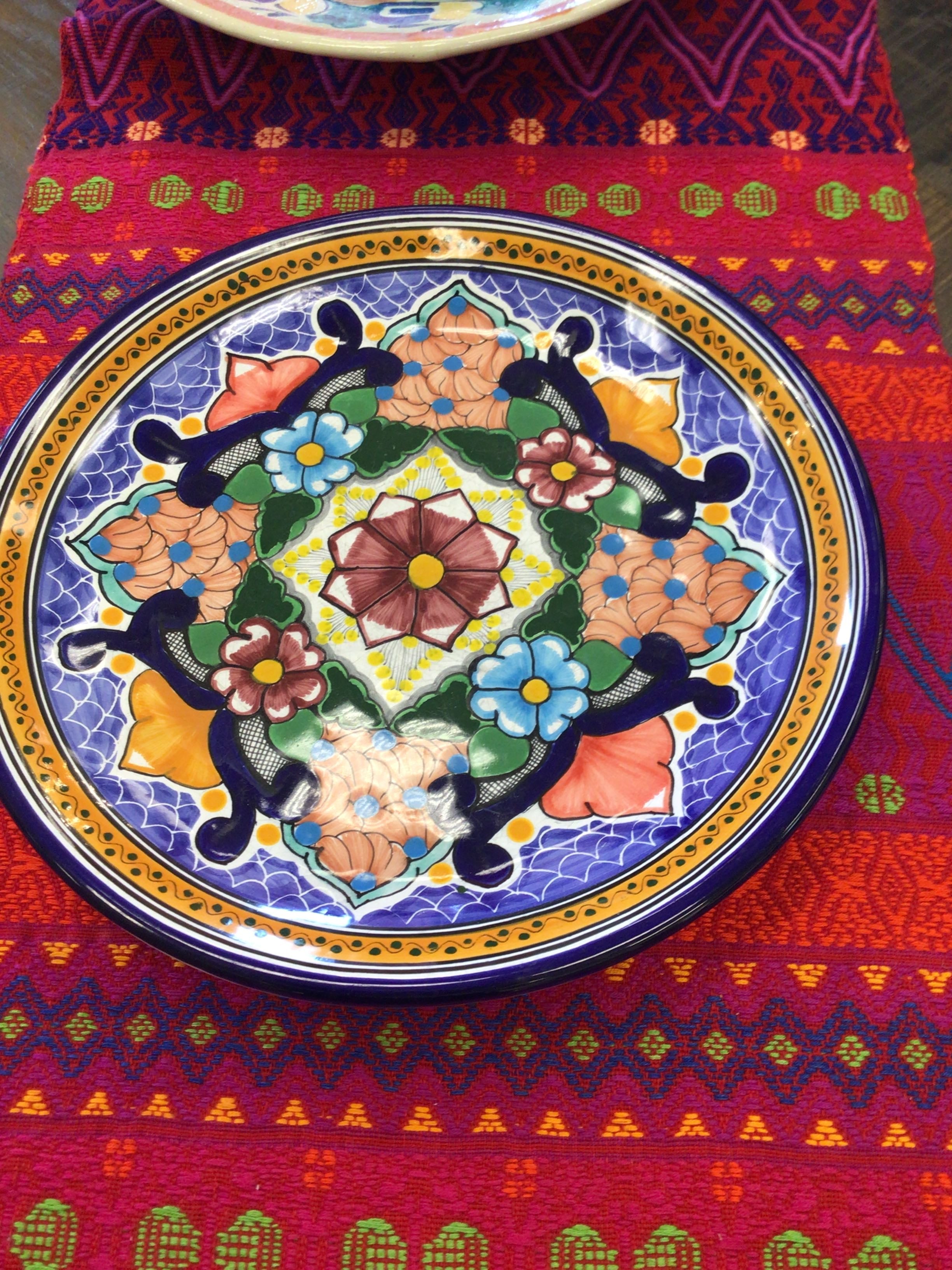 Decorative plate with floral patterns on a colorful fabric background