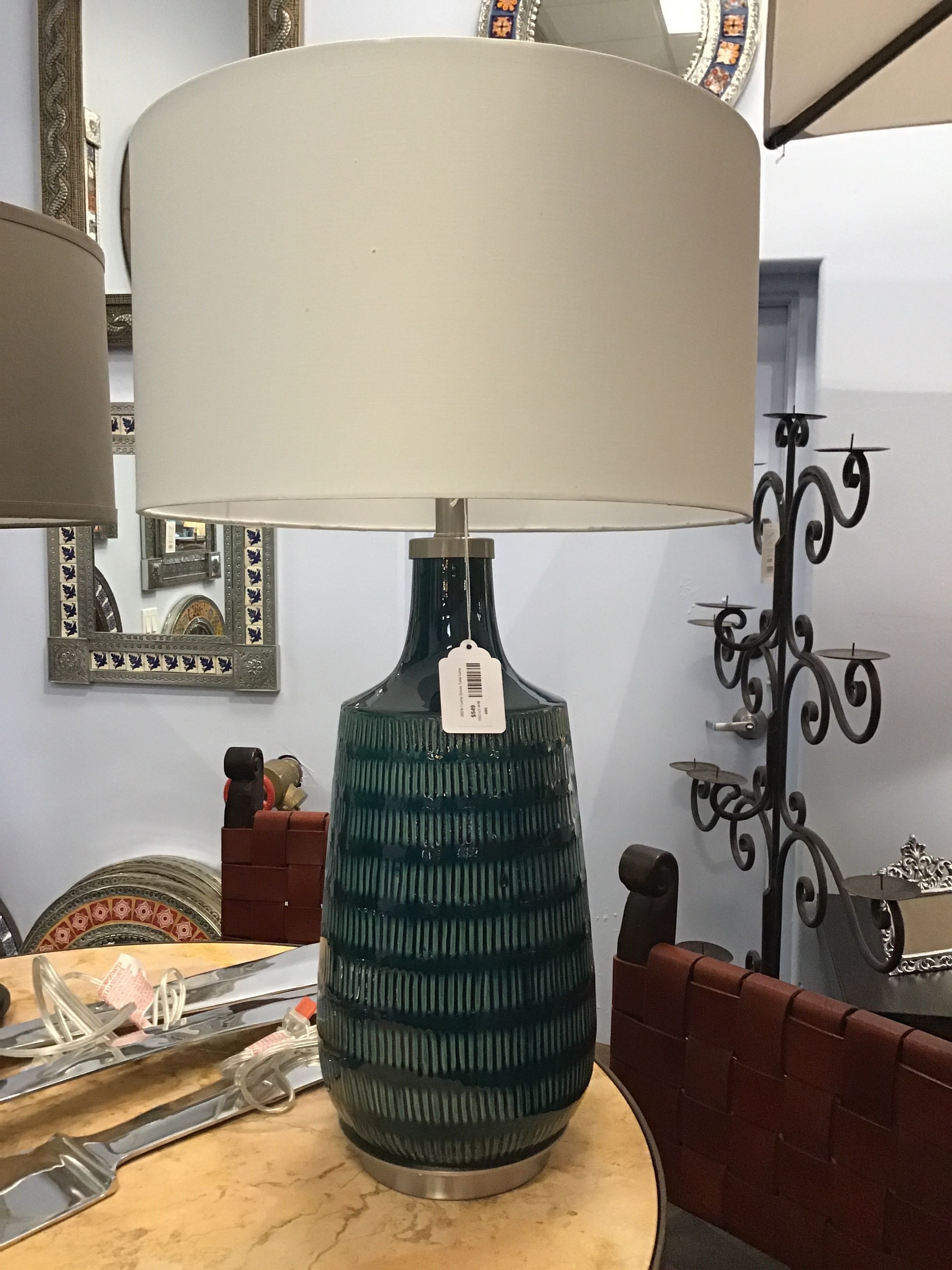 Decorative lamp with a textured base on a table in a room setting.