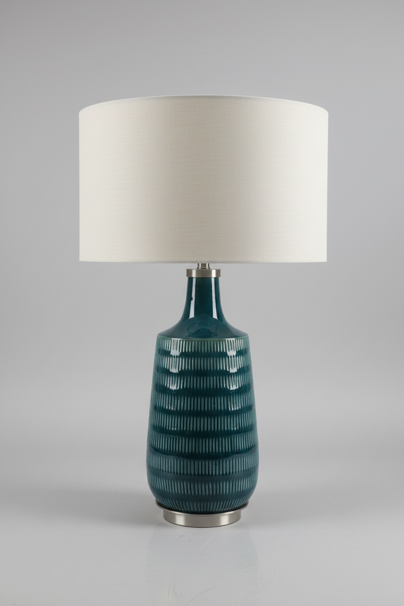 Teal ceramic table lamp with a white lampshade on a gray background