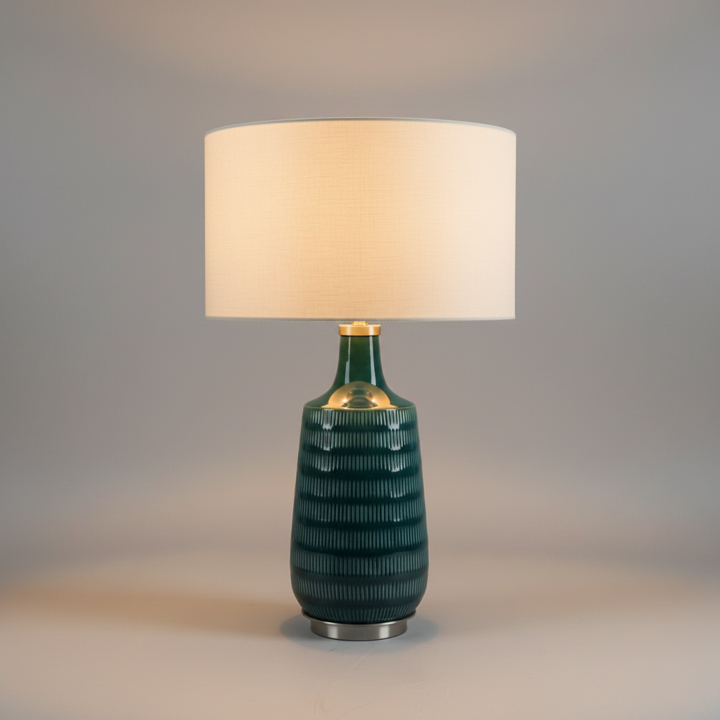 Table lamp with a textured green base and beige shade on a gray background