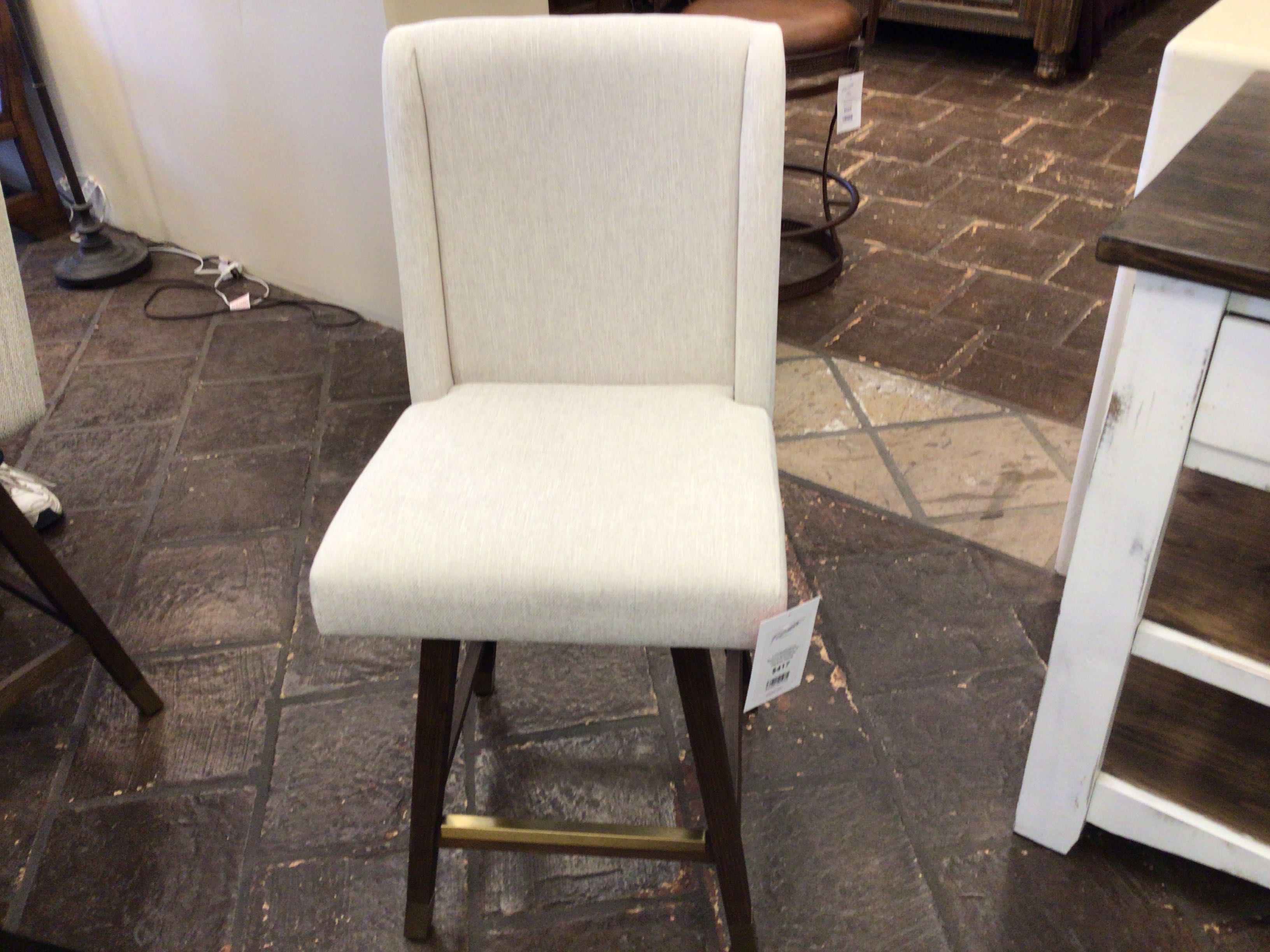 White bar stool with wooden legs on a stone floor