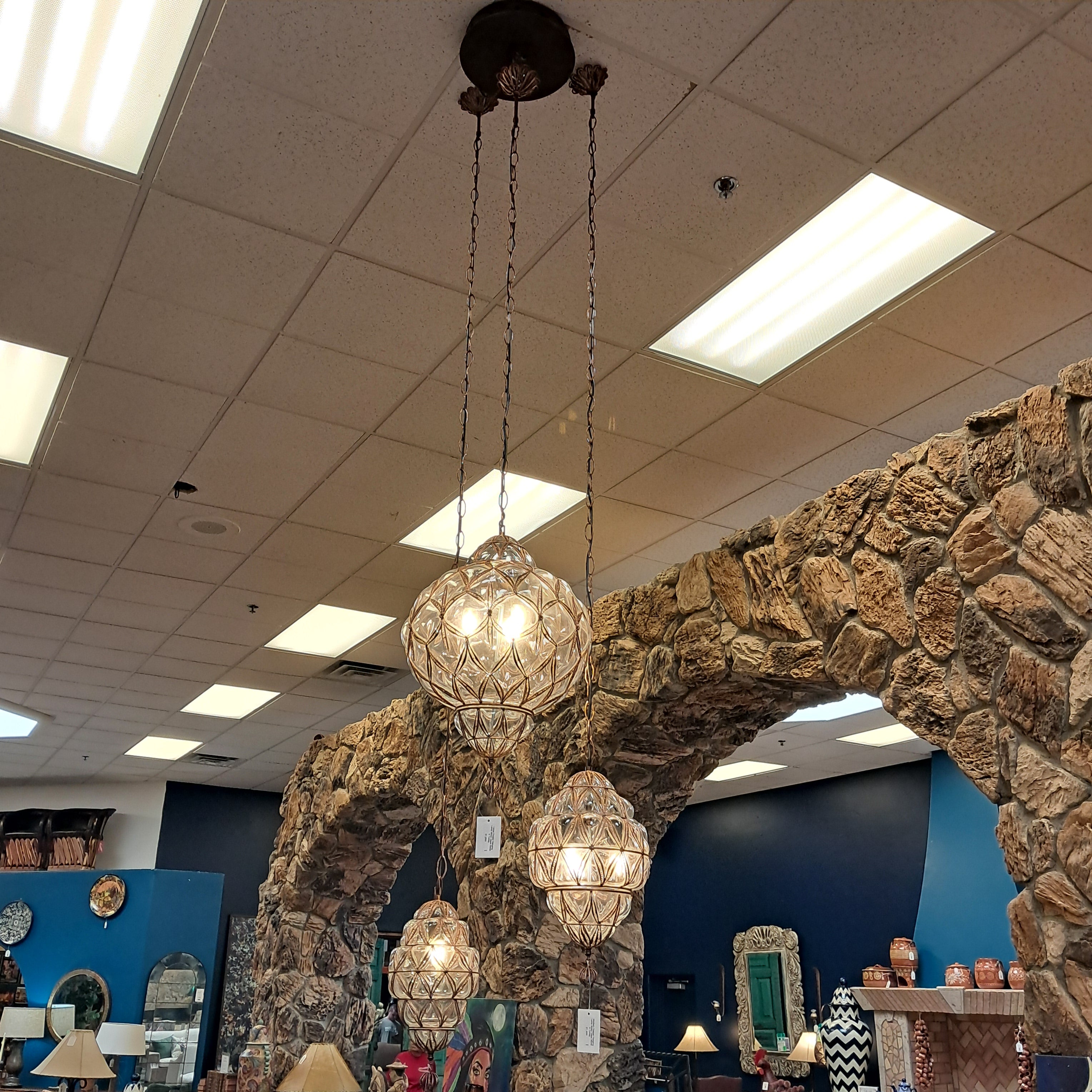 Chandelier hanging from a stone archway in a store setting