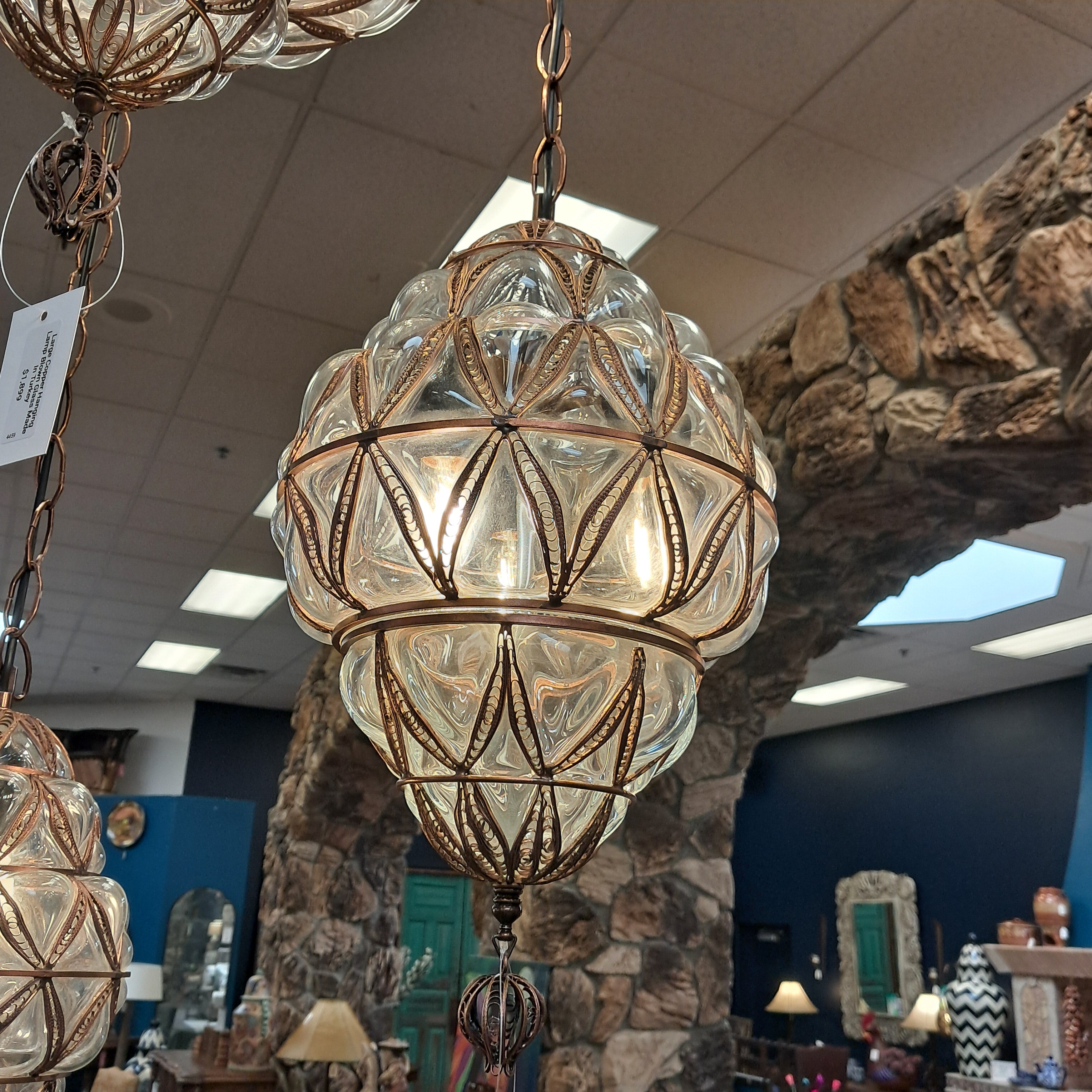 Decorative glass pendant light with gold accents in a store setting