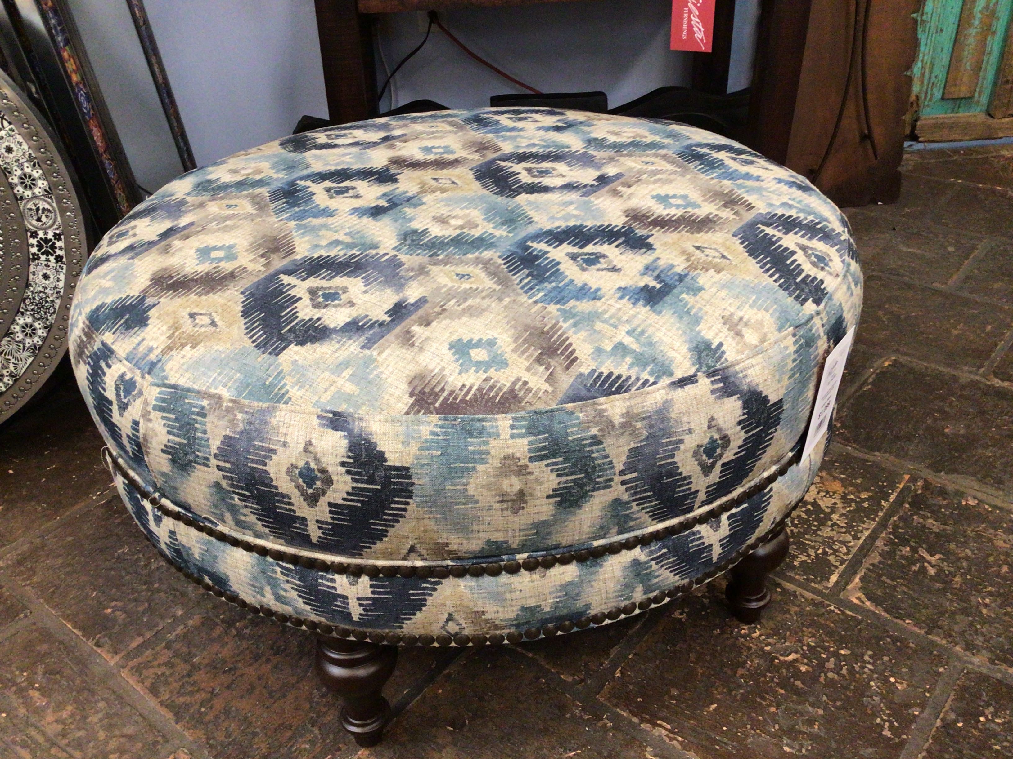 Round ottoman with blue and beige pattern on a stone floor
