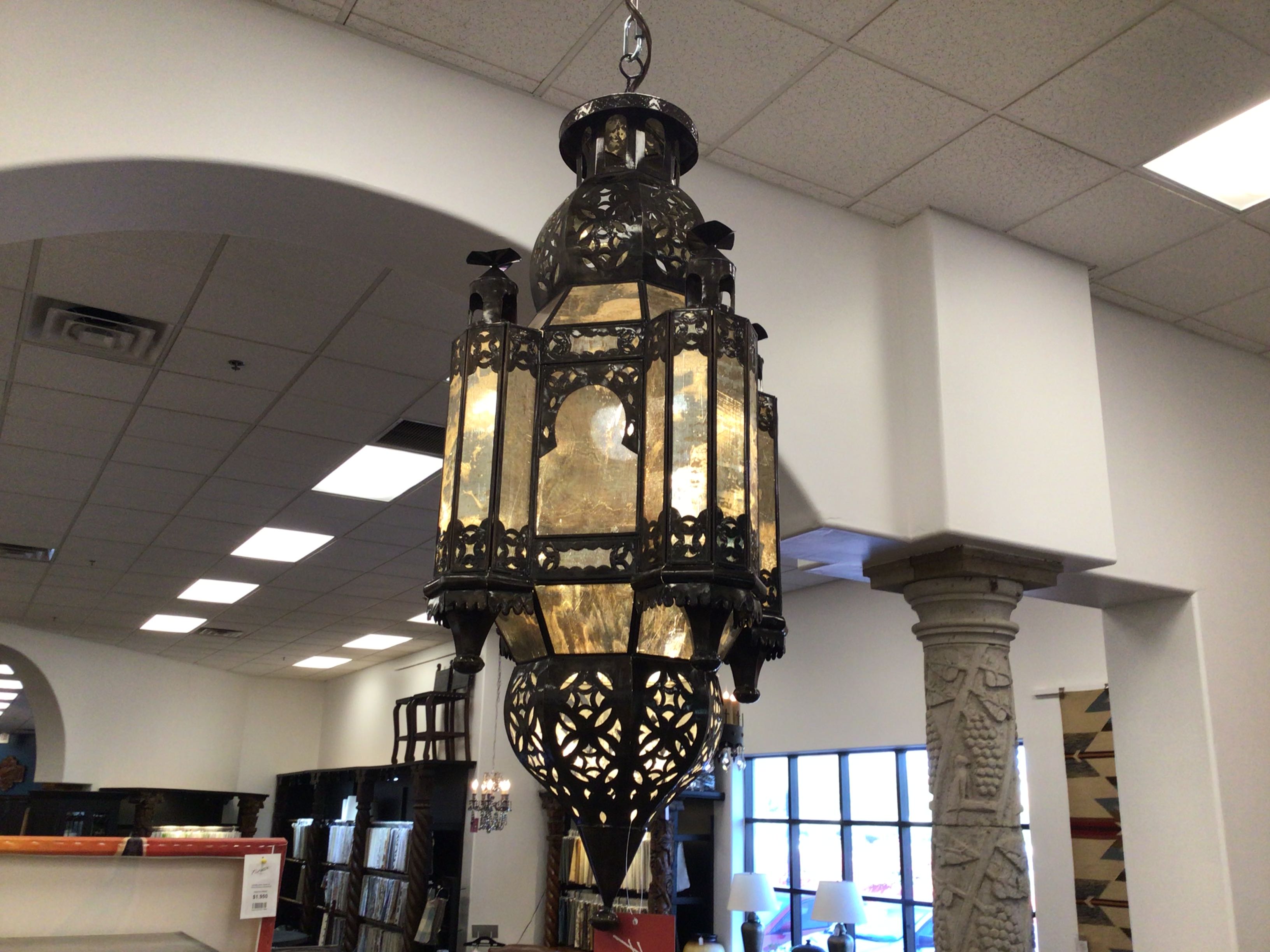 Decorative chandelier hanging in a store with books and columns in the background