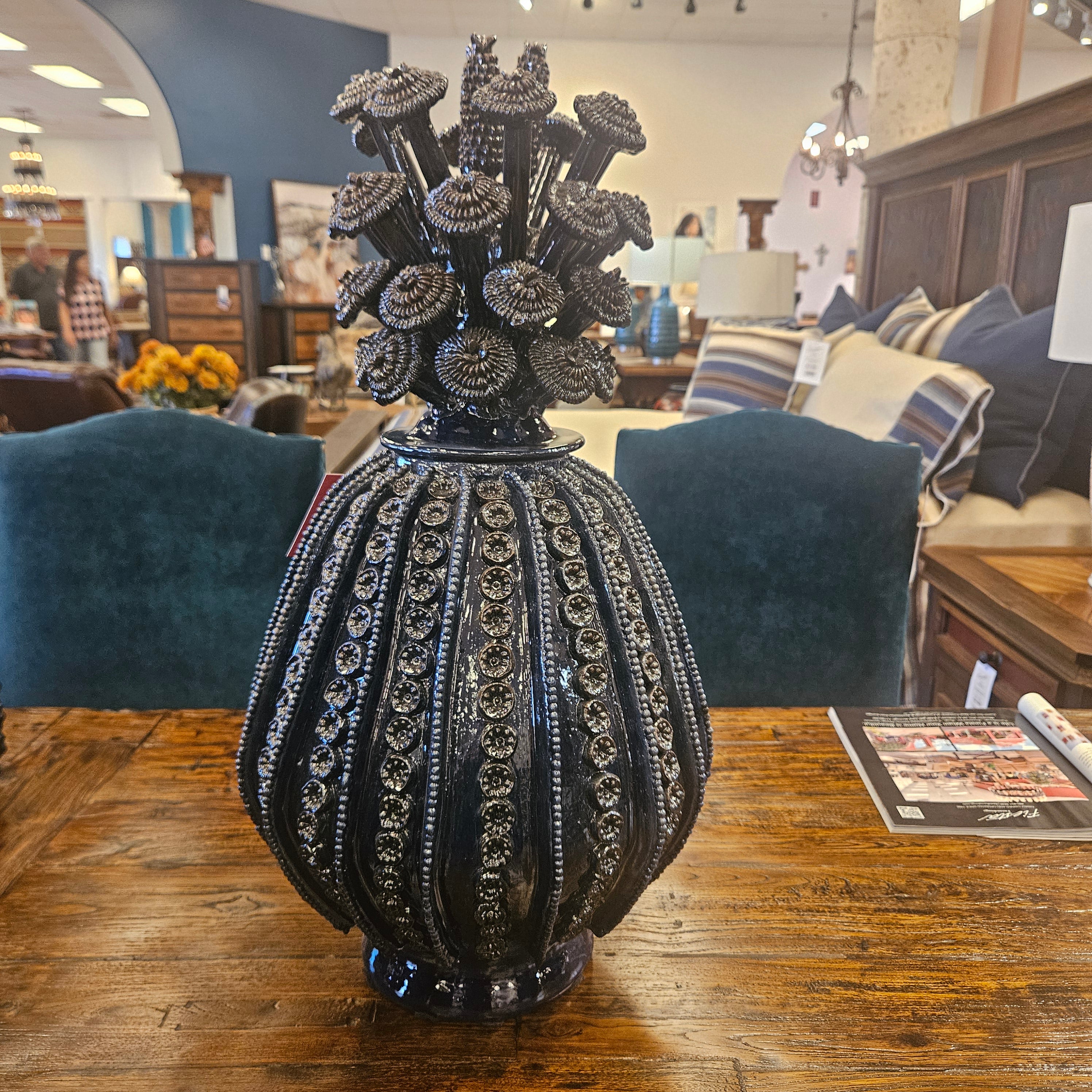 Decorative black vase with intricate detailing on a wooden surface