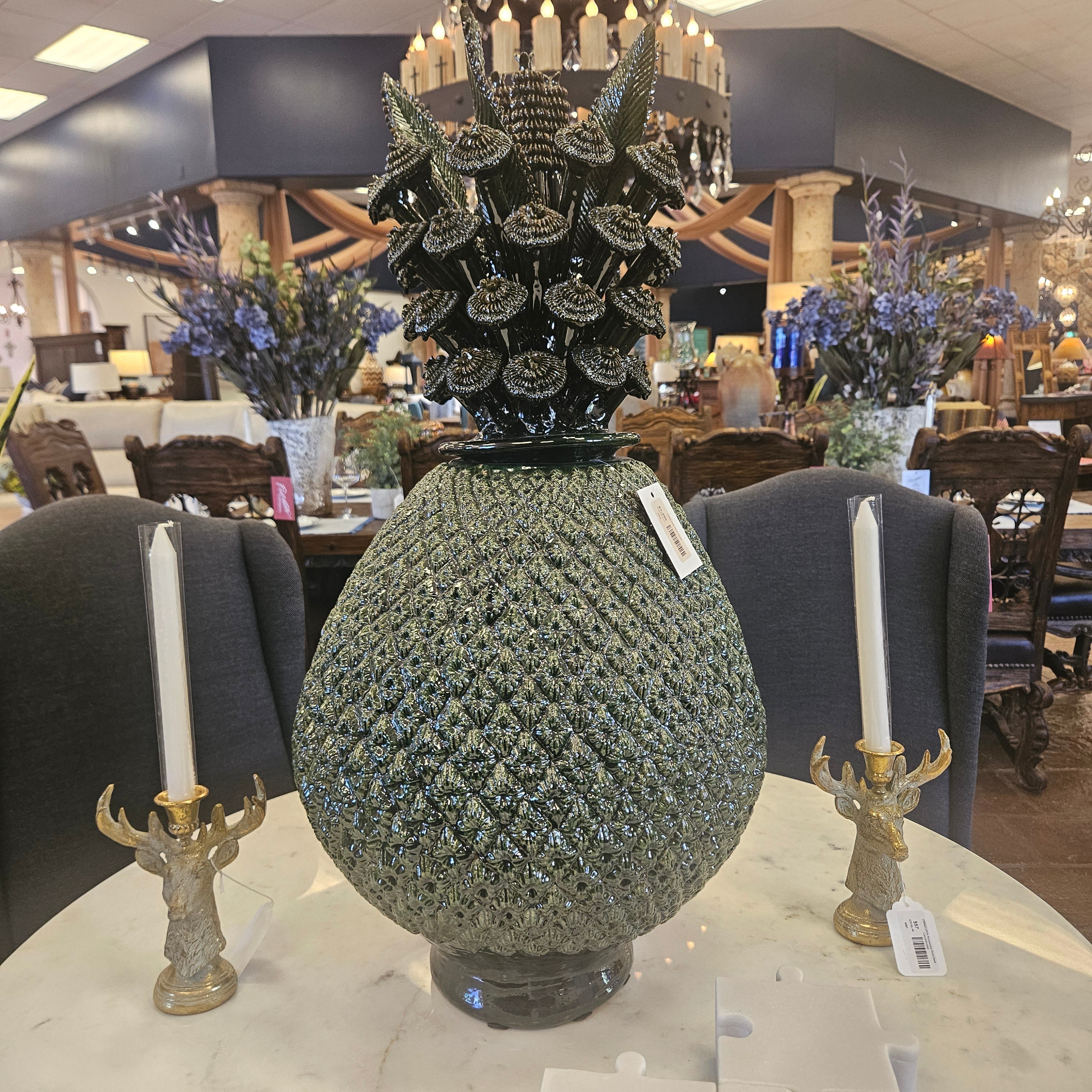 Green textured vase on a mannequin in a store setting with decorative items.