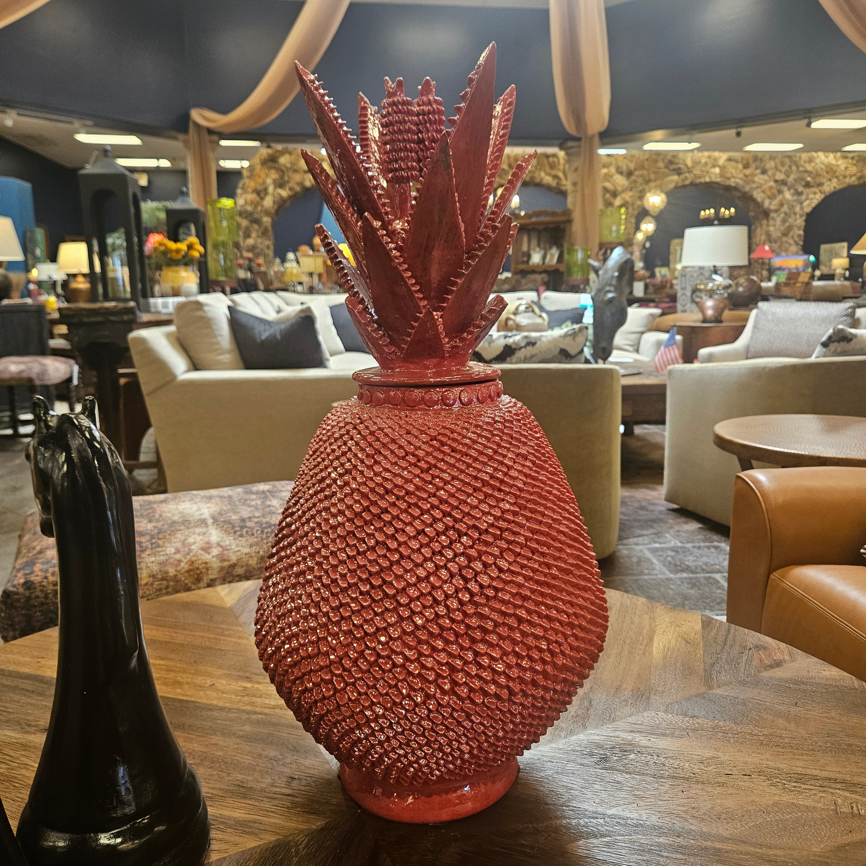 Decorative red pineapple on a bar counter with a blurred bar setting in the background