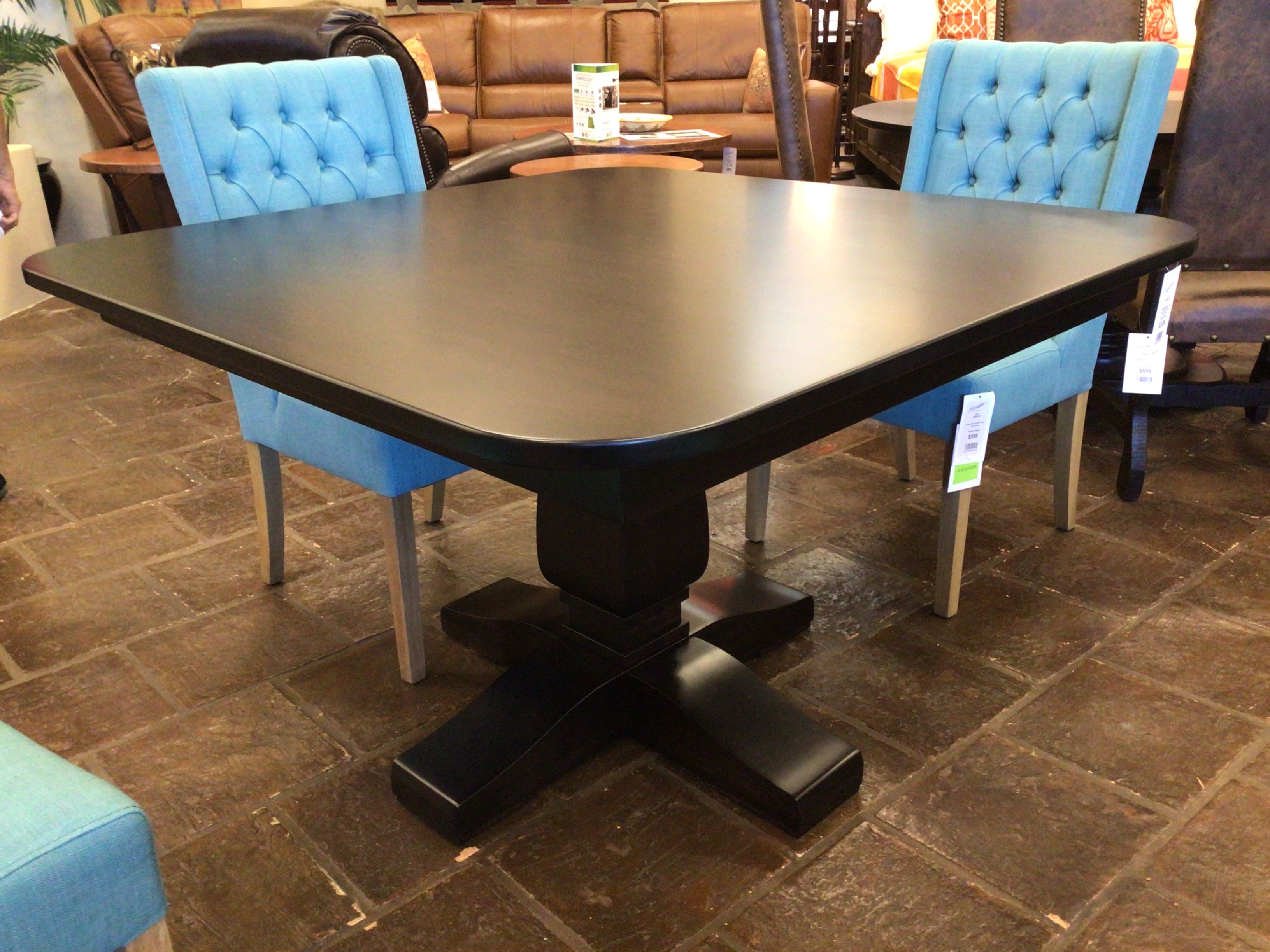 Dining table with blue chairs on a stone floor