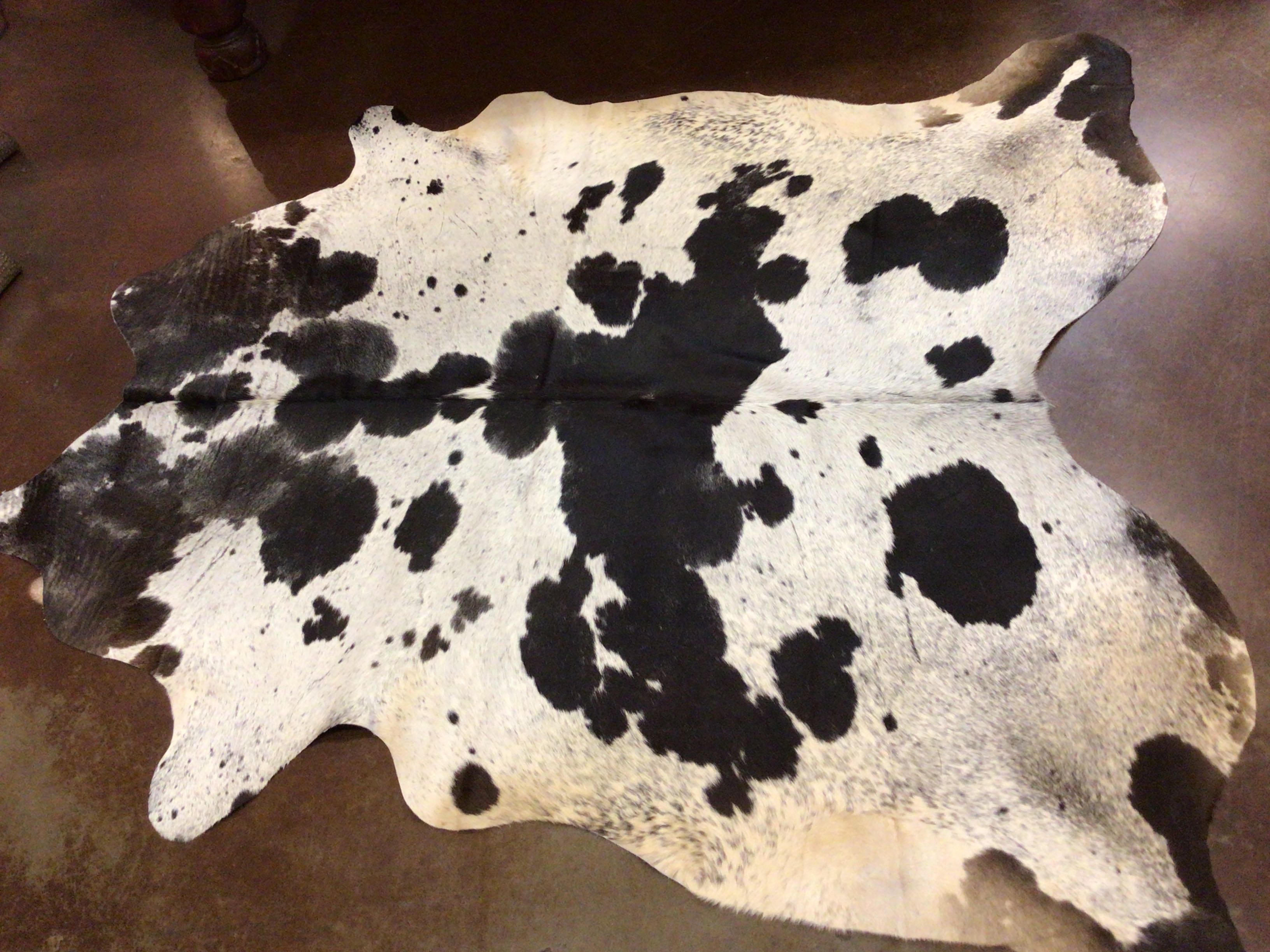 Black and white cowhide rug on a brown surface