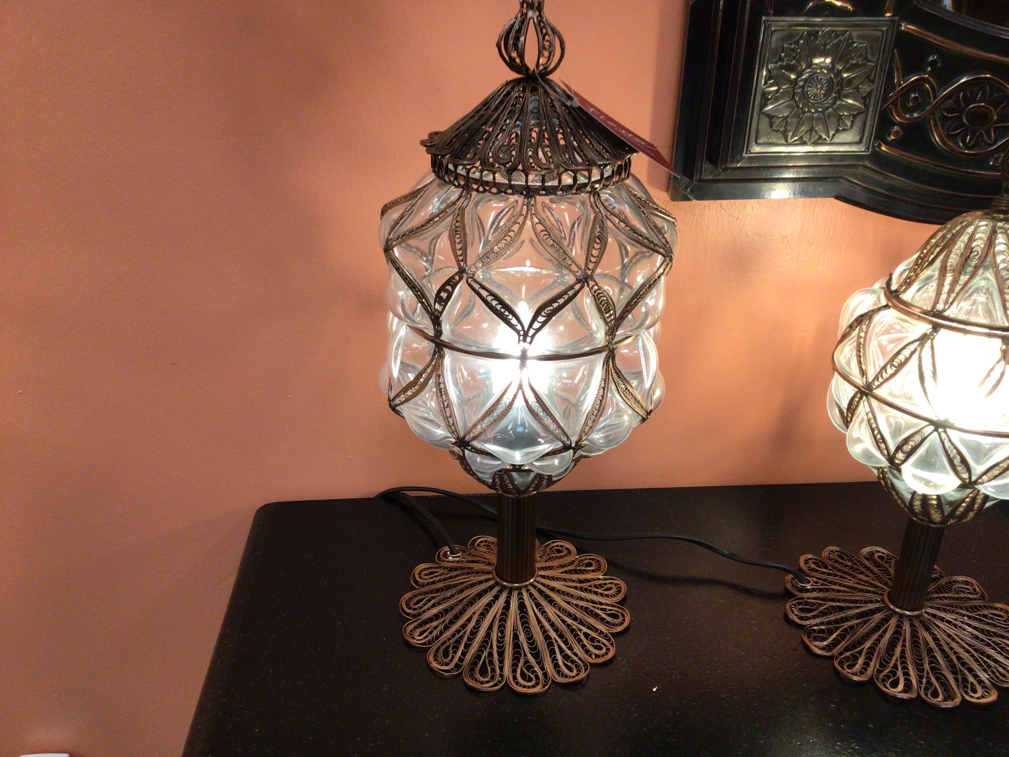 Decorative table lamp with intricate design on a dark surface.
