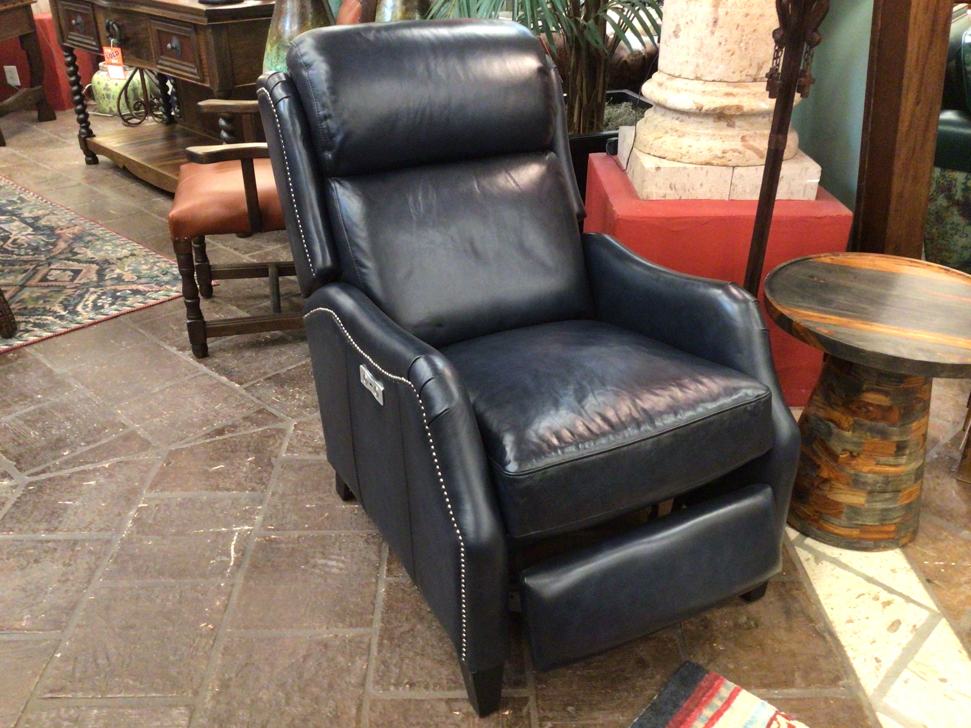 Black leather recliner chair in a room with furniture and decor.