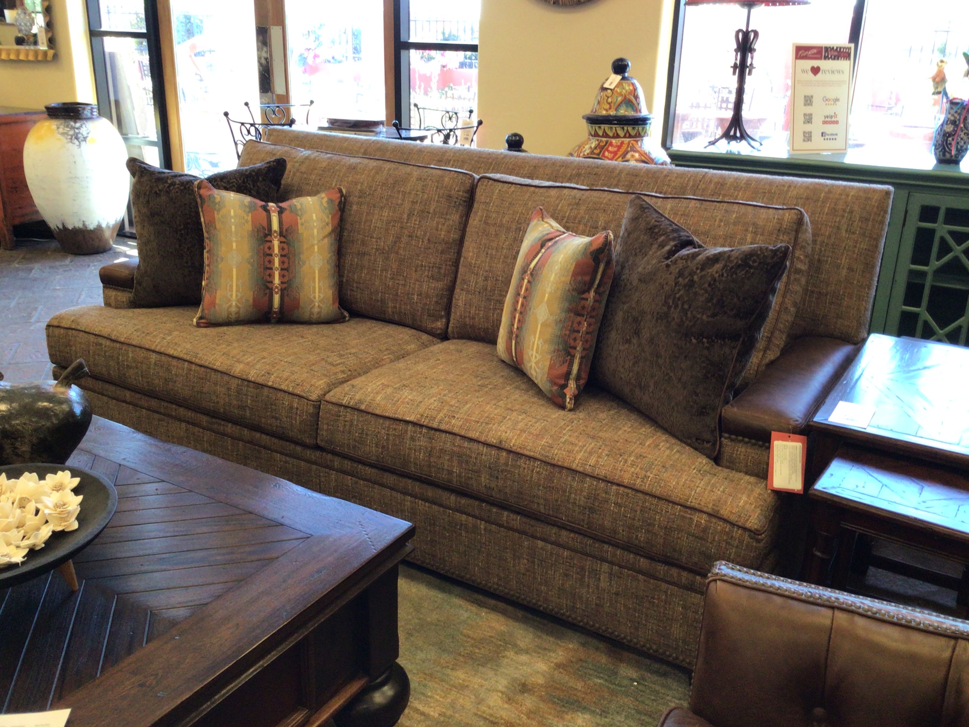 Brown sectional sofa with patterned pillows in a living room setting.