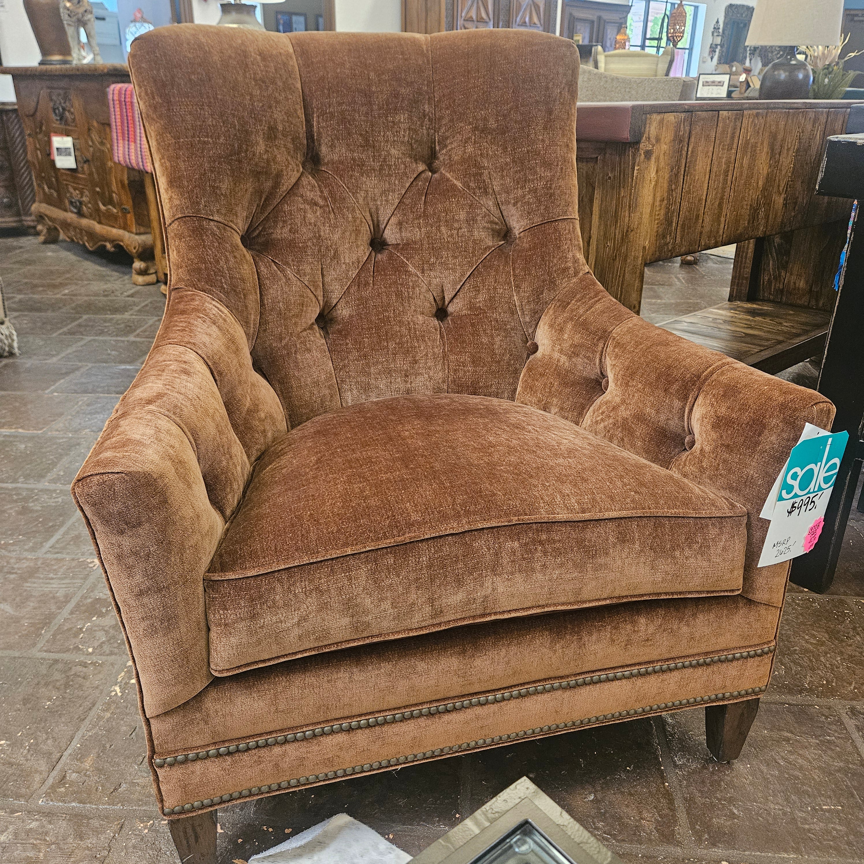 Brown upholstered chair with tufted backrest in a store setting