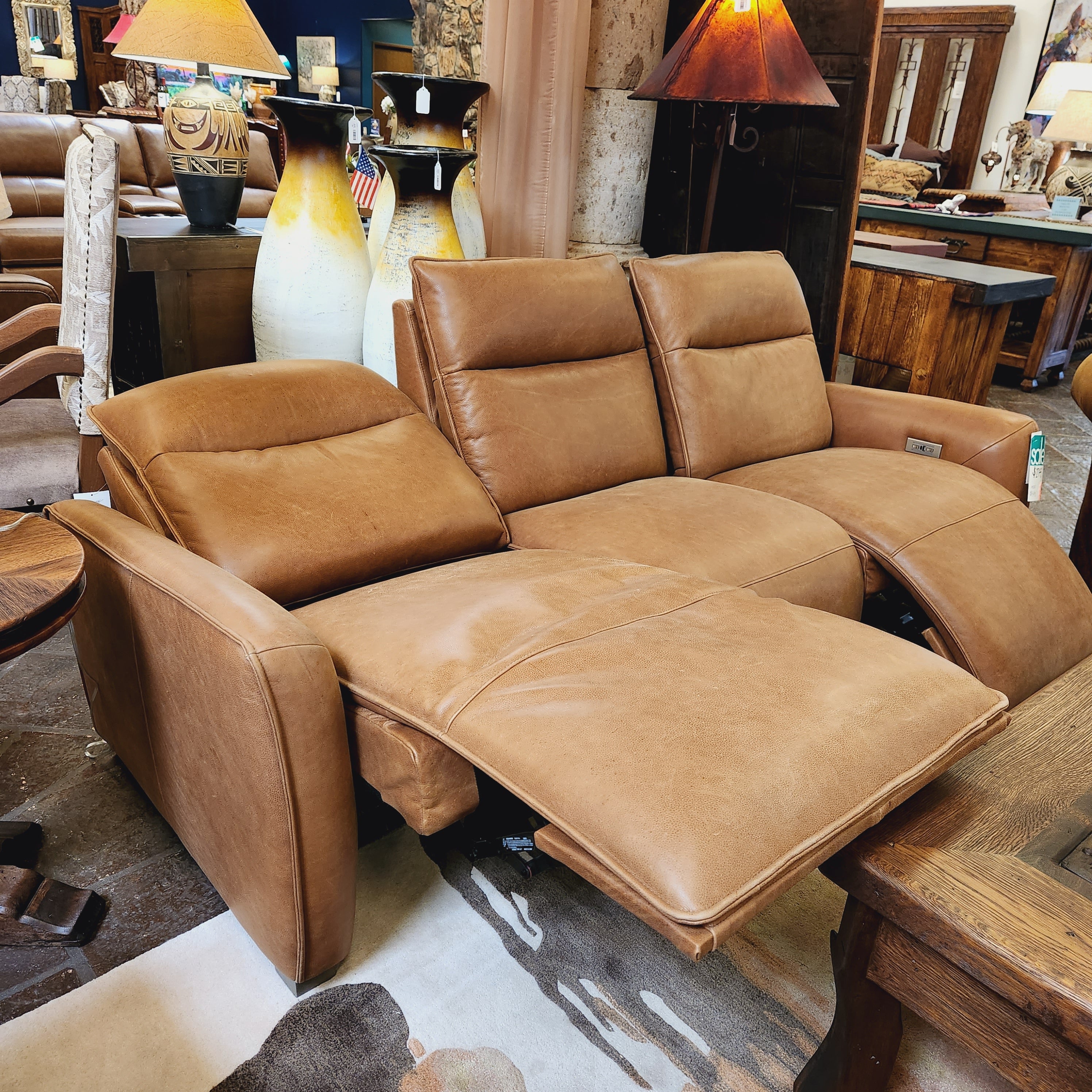 Brown leather sectional sofa in a room with wooden furniture and decor.