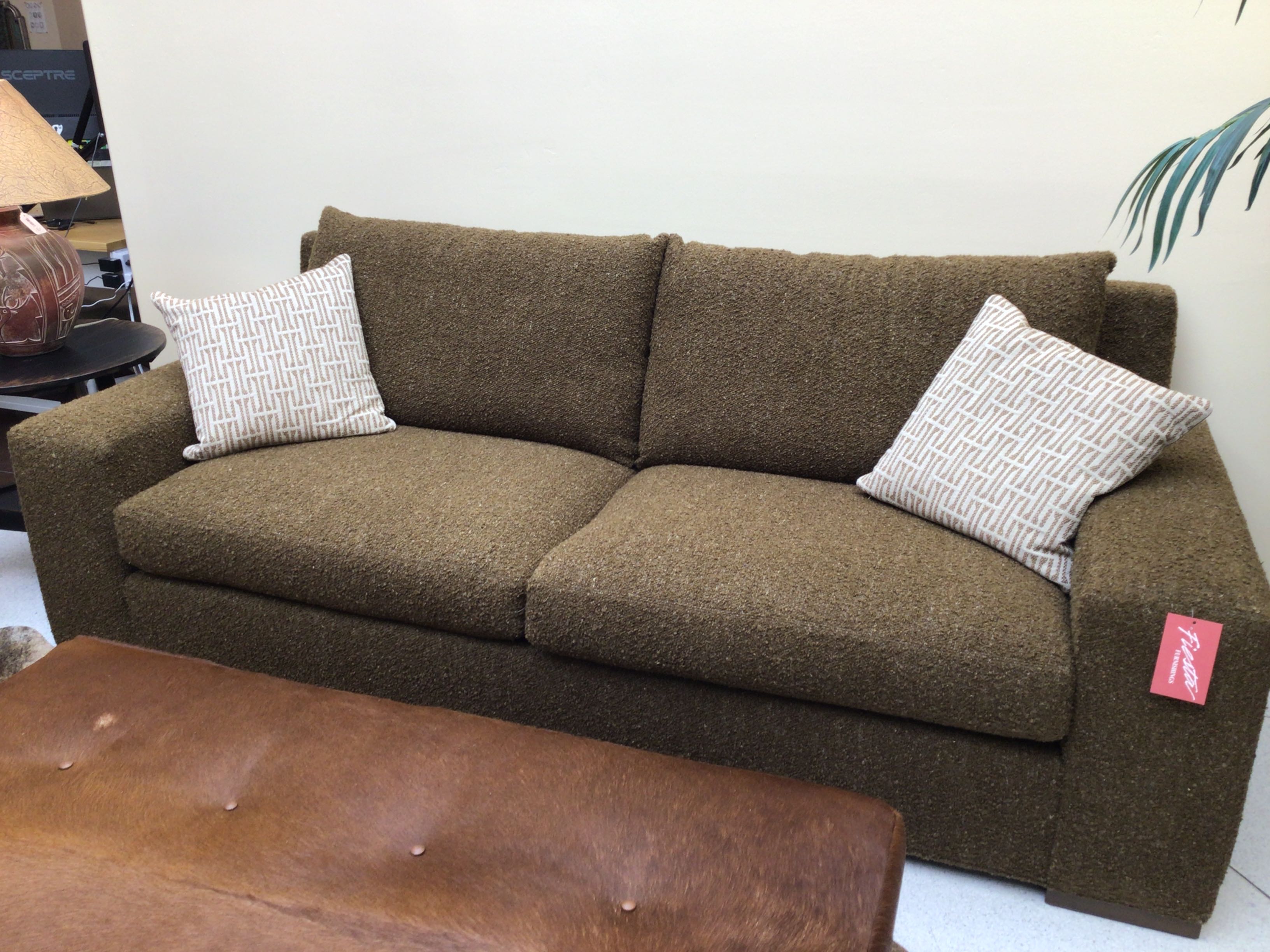 Brown sofa with patterned cushions in a room setting