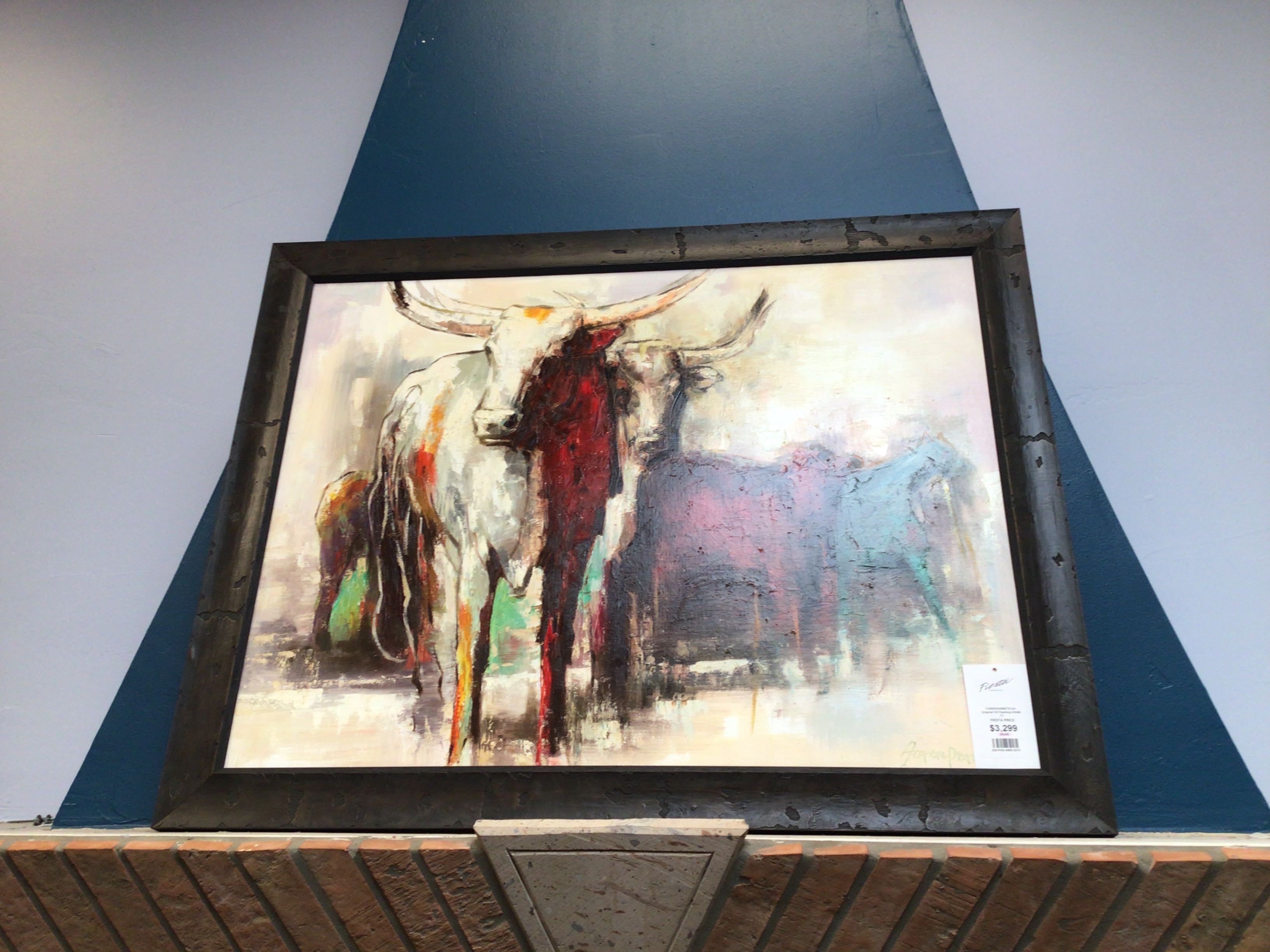 Framed abstract painting of a bull on a wall.