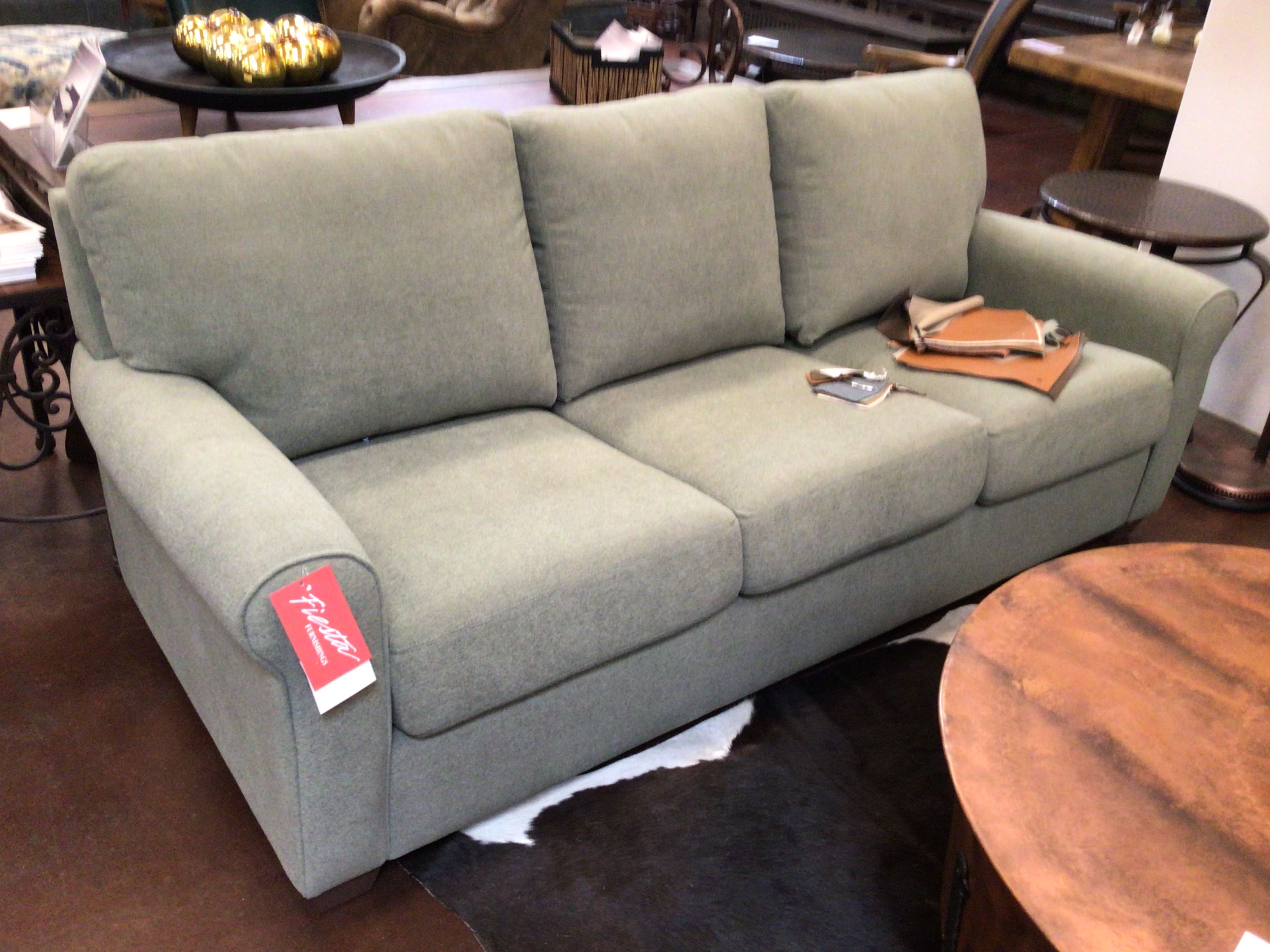 Green sofa with a price tag in a store setting