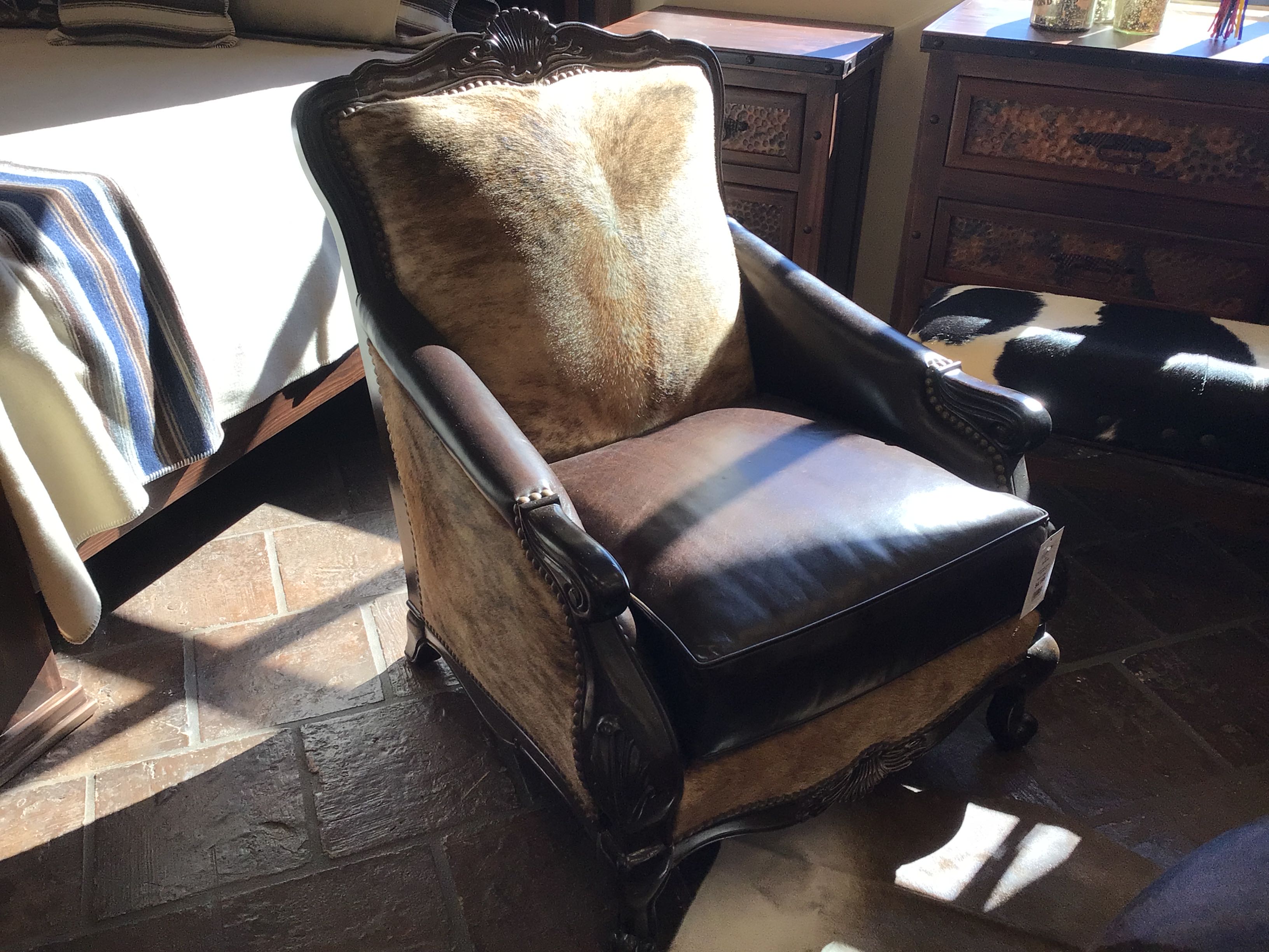 Vintage armchair with a cushion in a room with wooden floors and furniture.