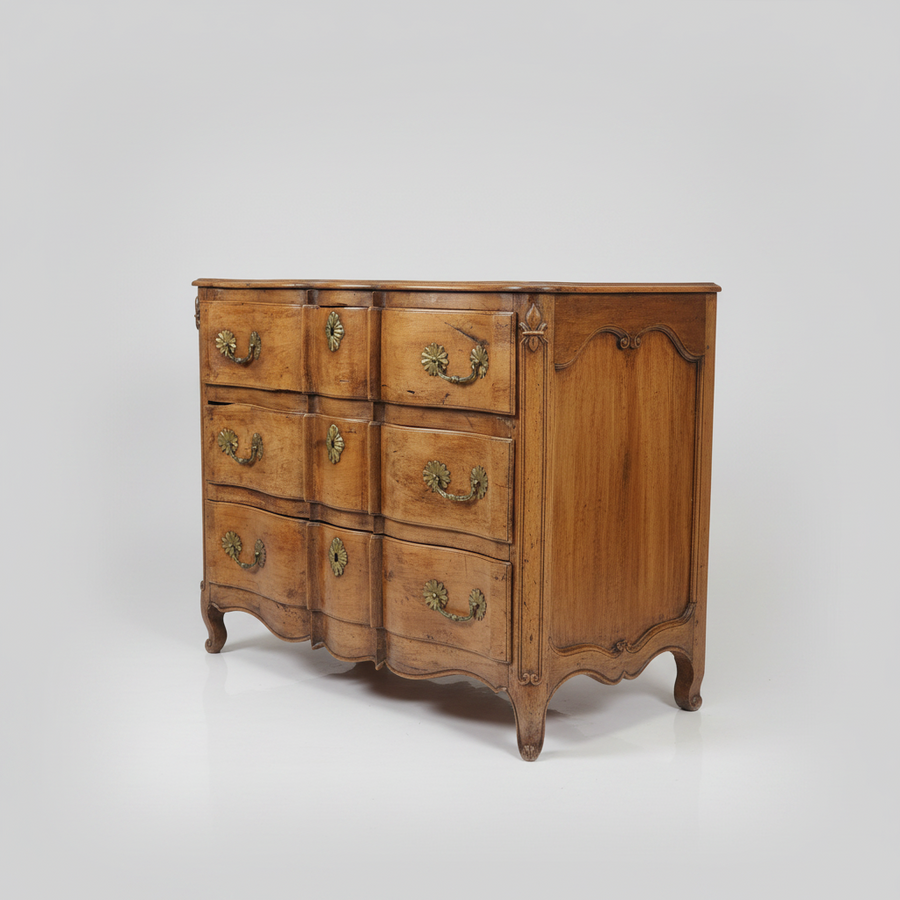 French antique wooden dresser with curved design and brass handles on a white background