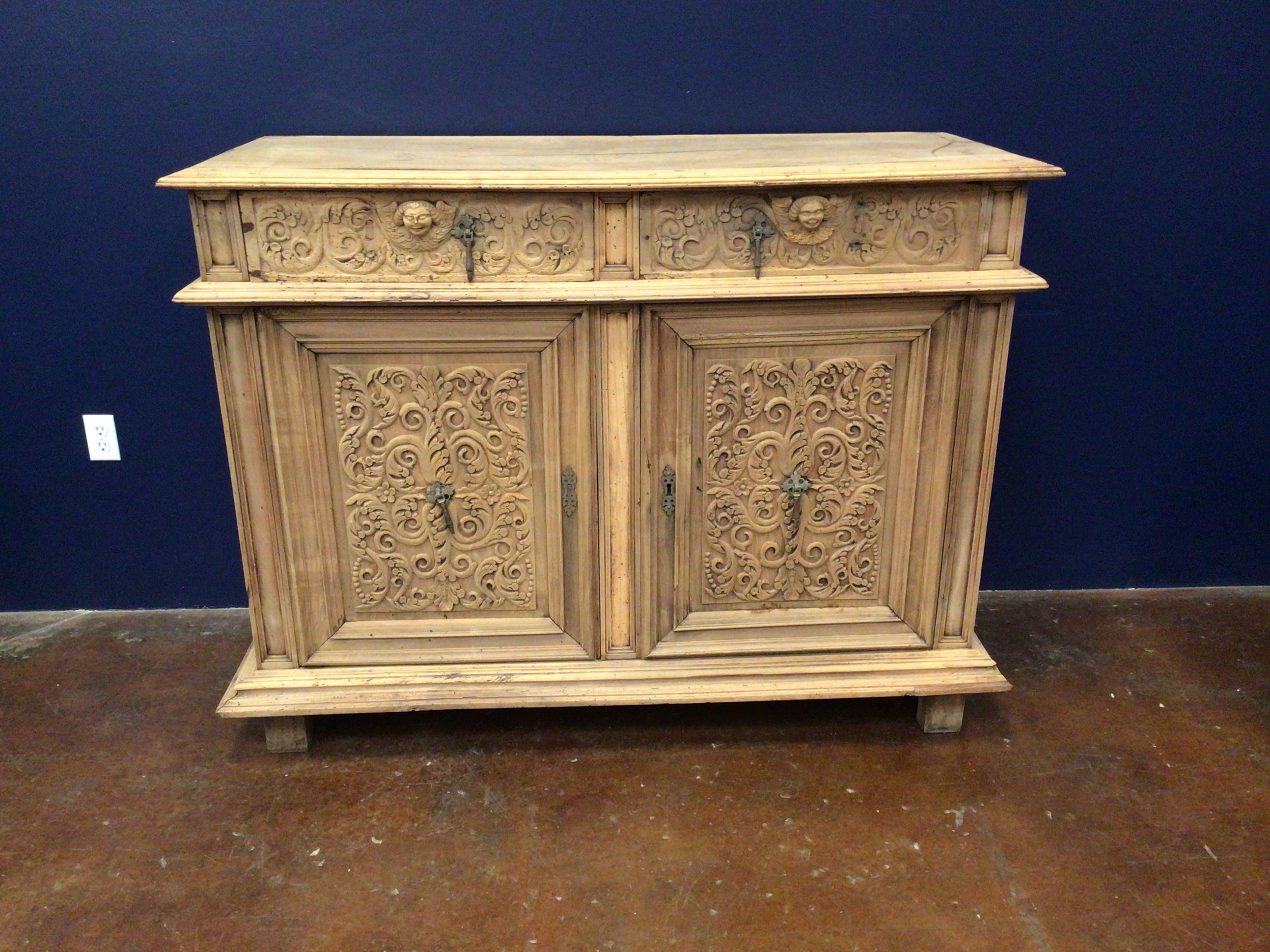 Wooden cabinet with intricate carvings against a blue wall