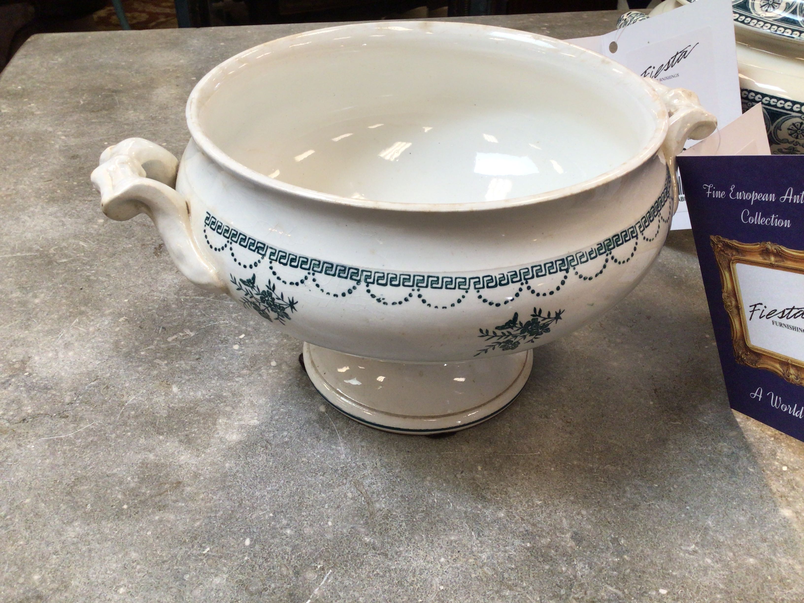 White ceramic urn with blue decorative patterns on a gray surface