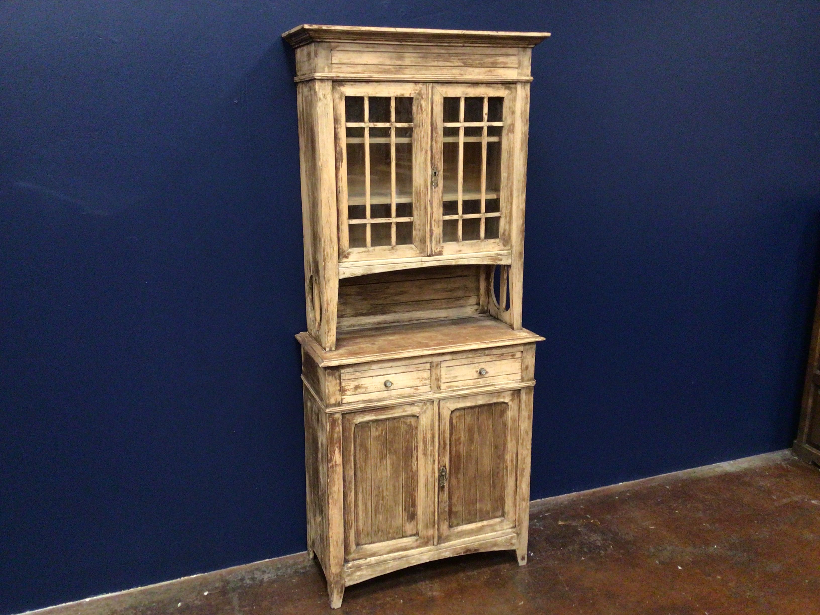 Wooden cabinet with glass doors against a blue wall