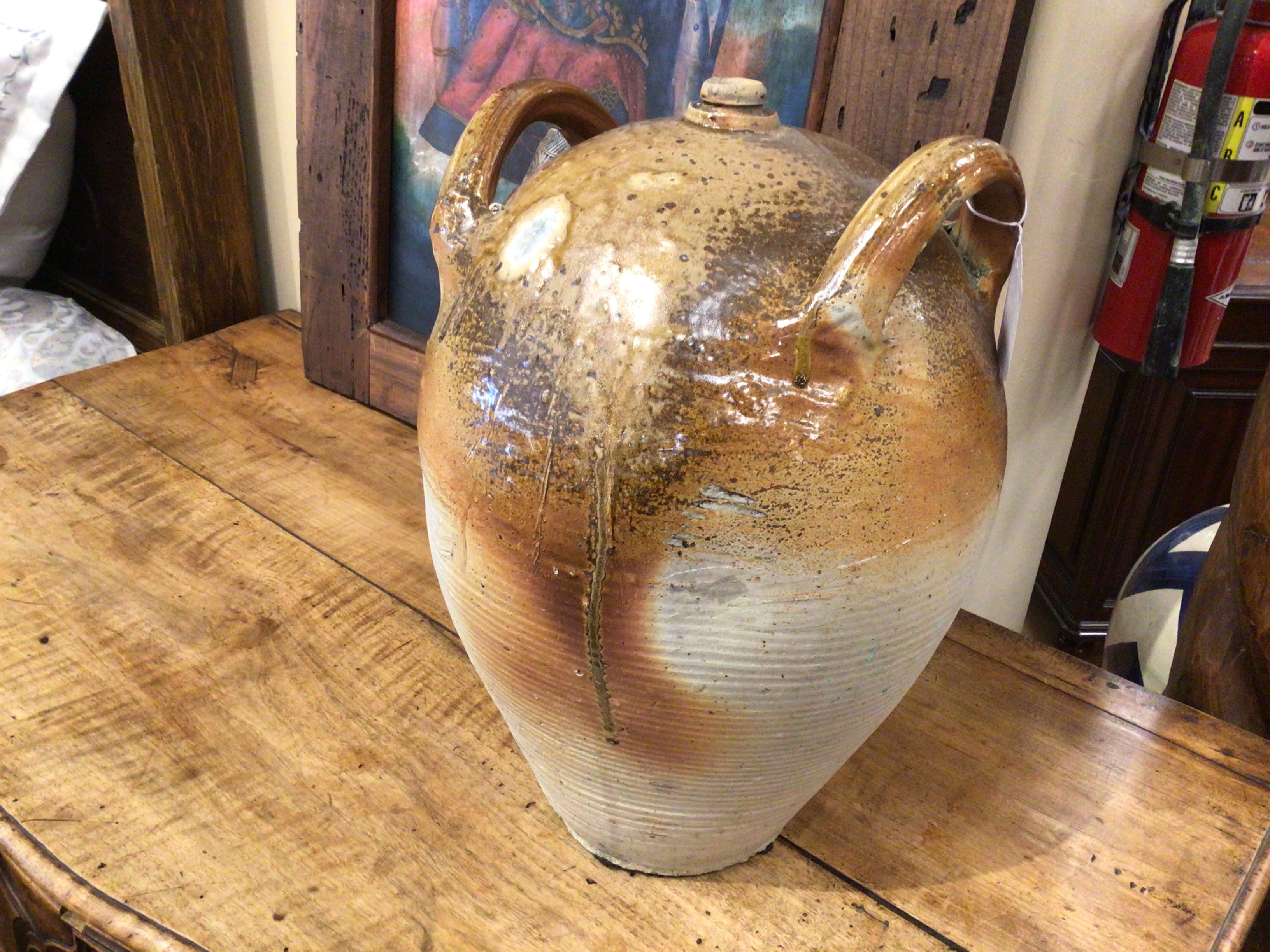 Vintage ceramic jar on a wooden surface with a blurred background