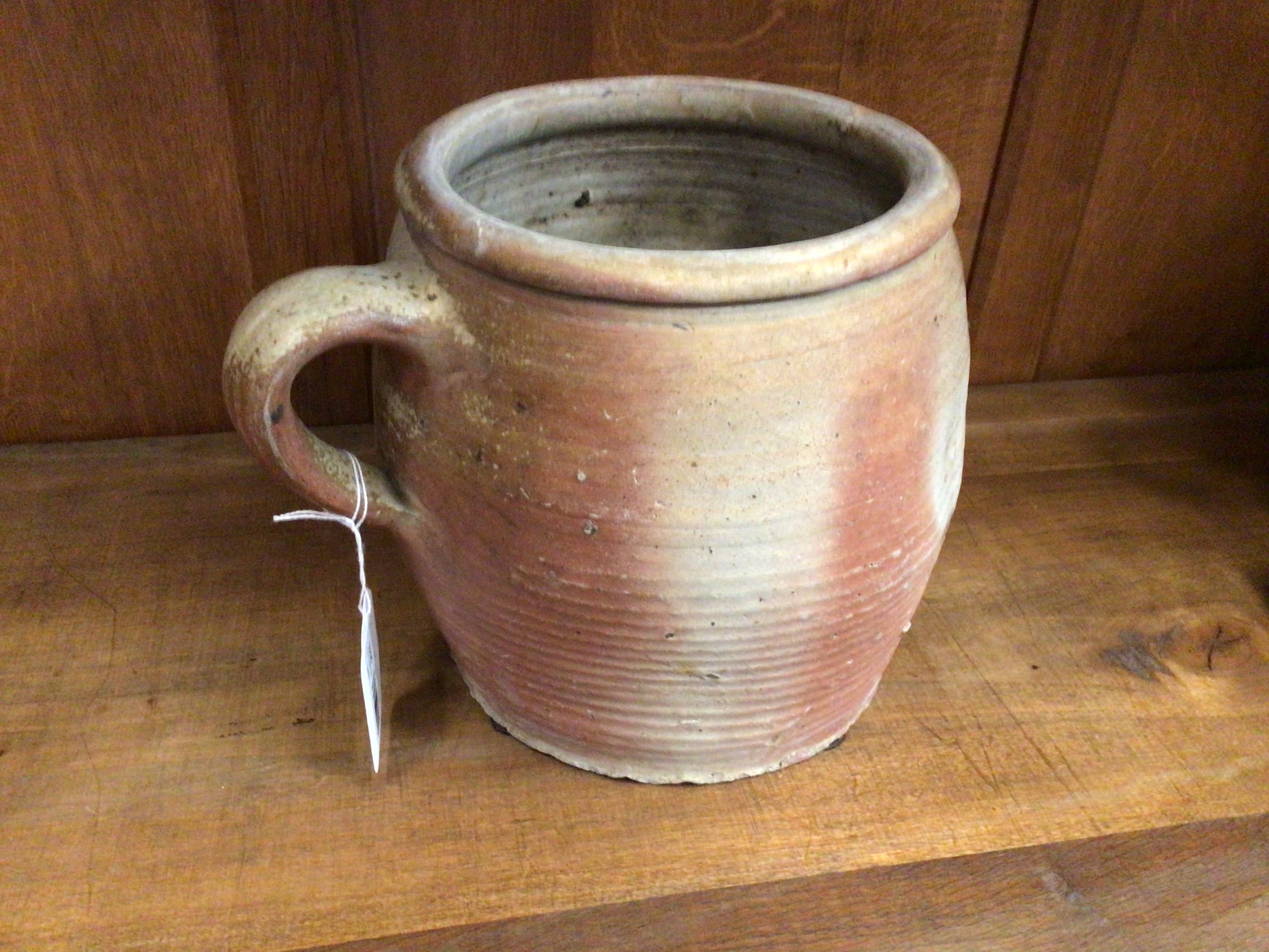 Terracotta mug on a wooden surface with a wooden background