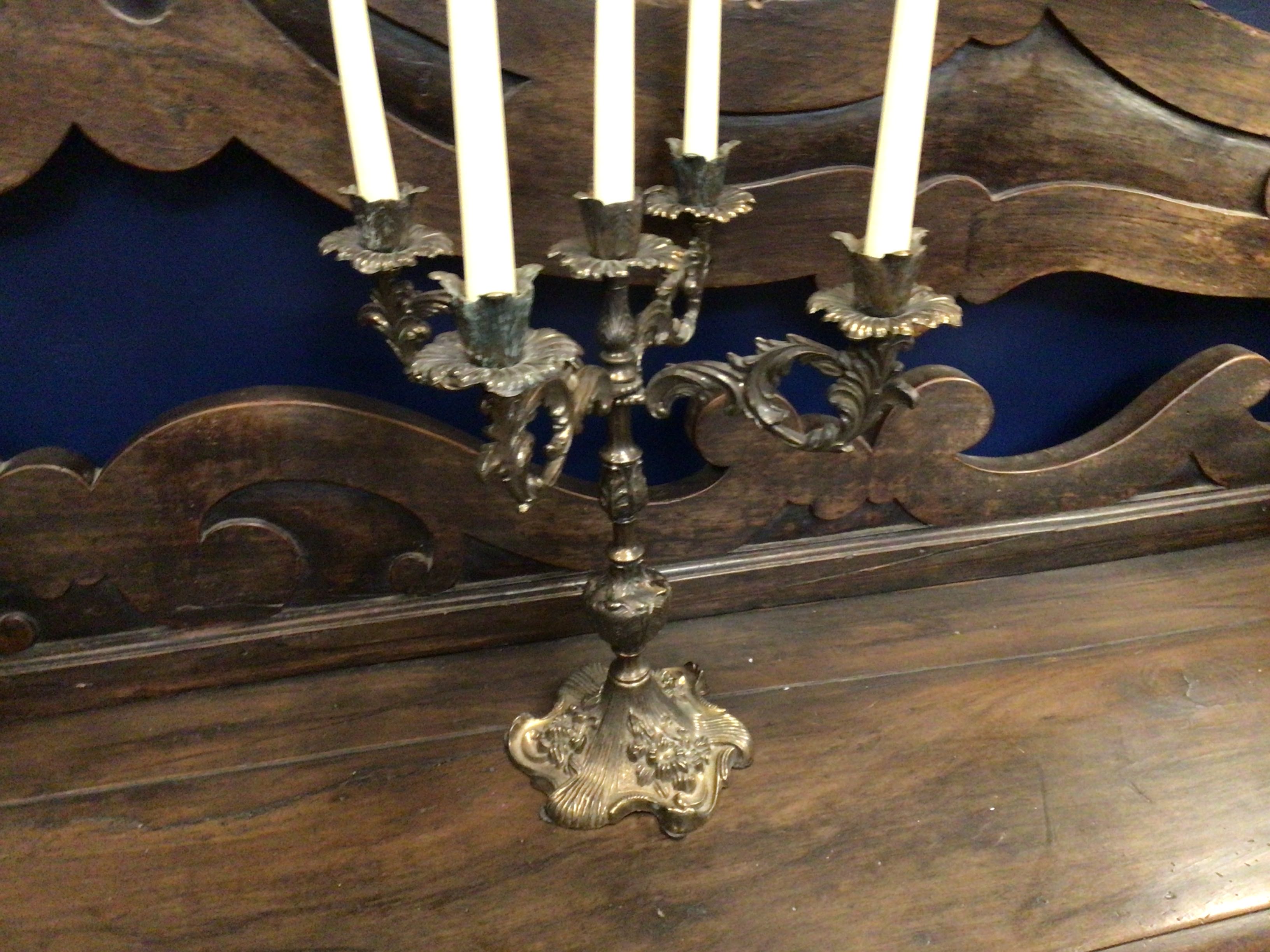 Decorative candle holder with four candles on a wooden surface