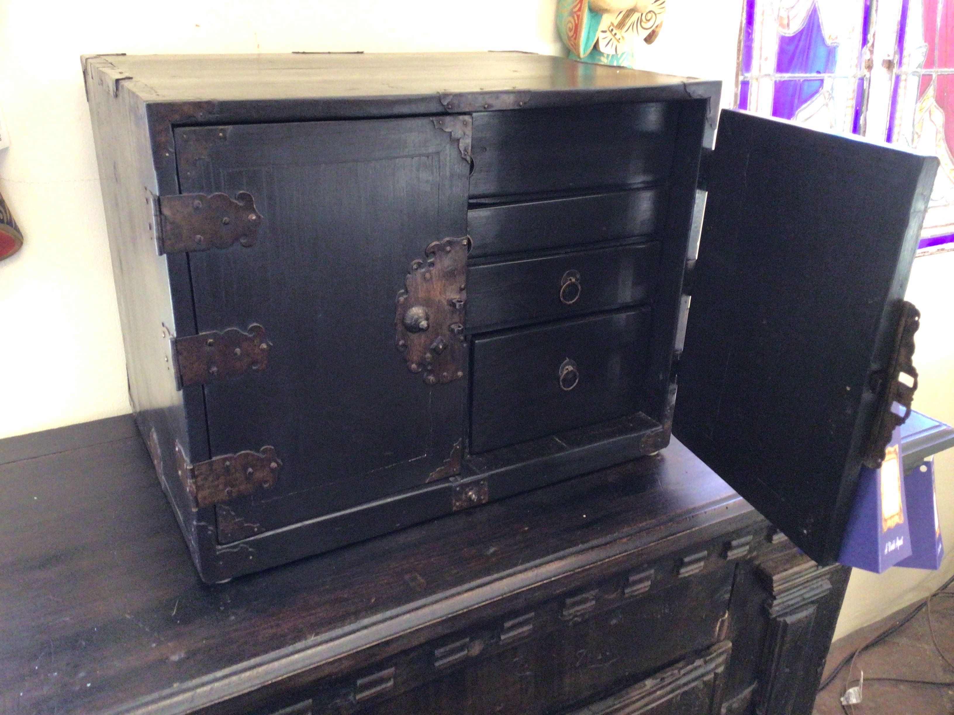 Black wooden chest with open lid on a wooden surface