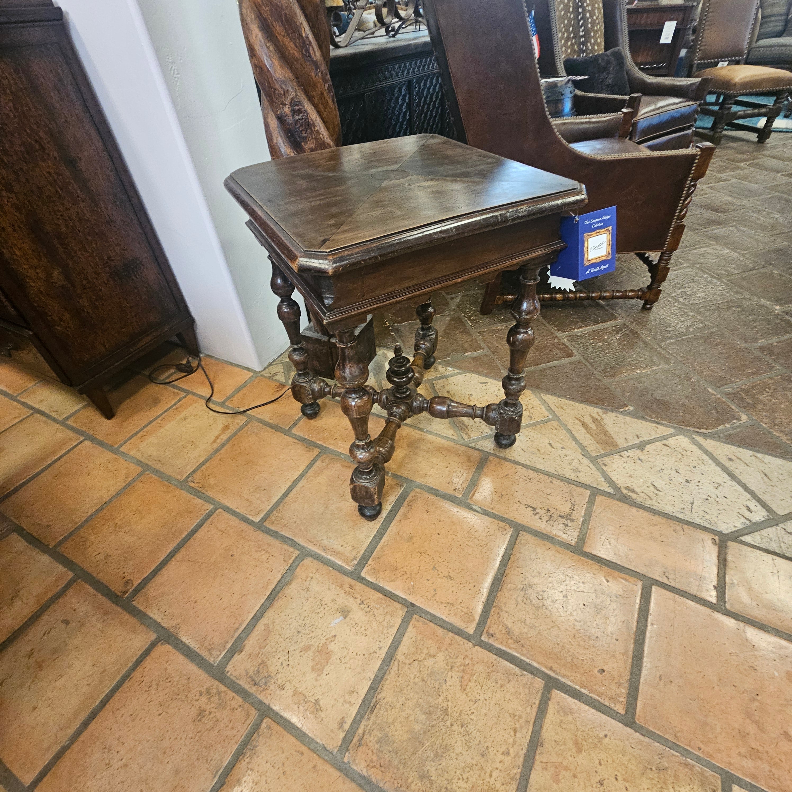 Wooden table with metal legs against a stone wall and tiled floor